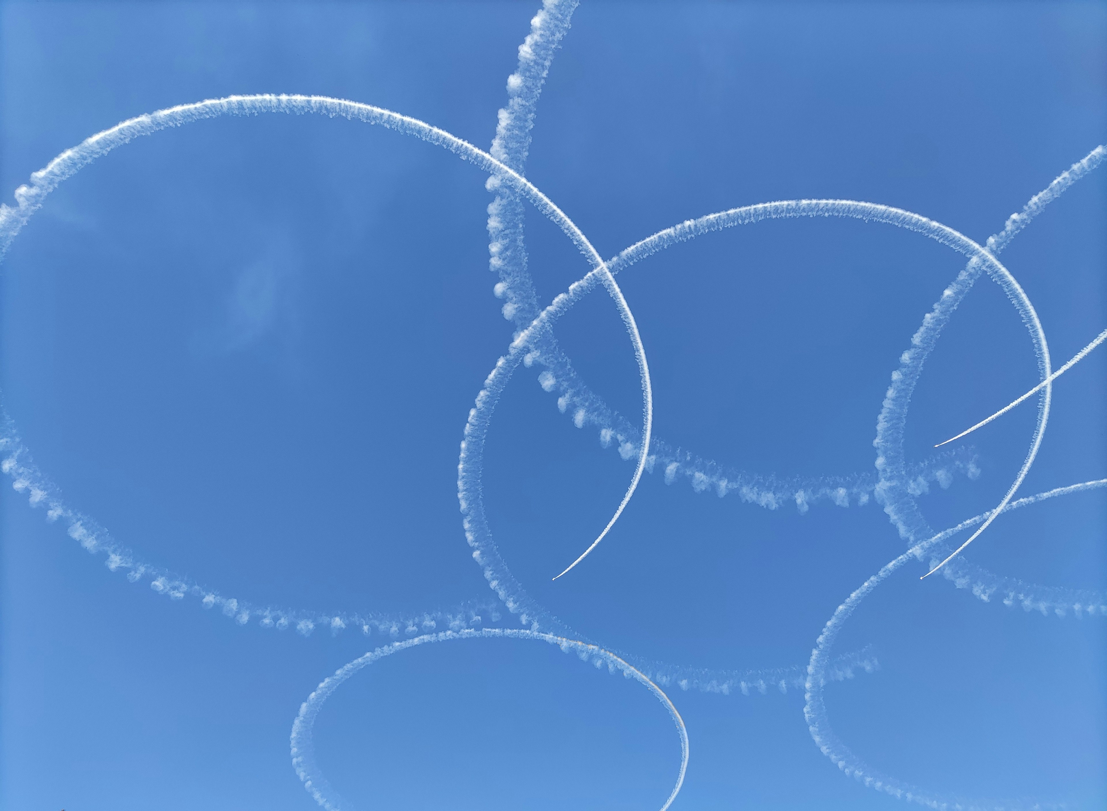 Motifs circulaires de fumée blanche contre un ciel bleu