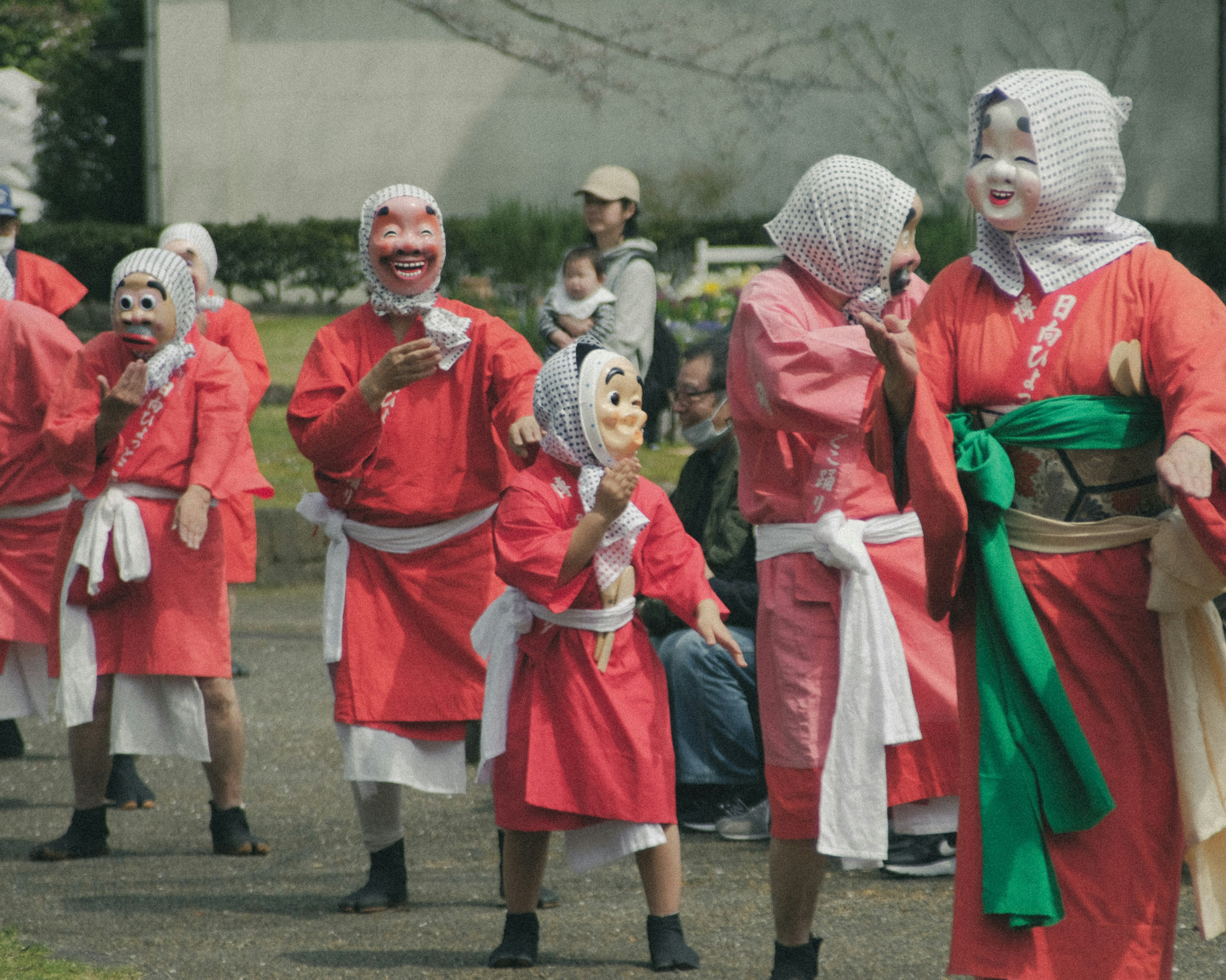 Grupo de personas con trajes rojos que llevan máscaras en un festival