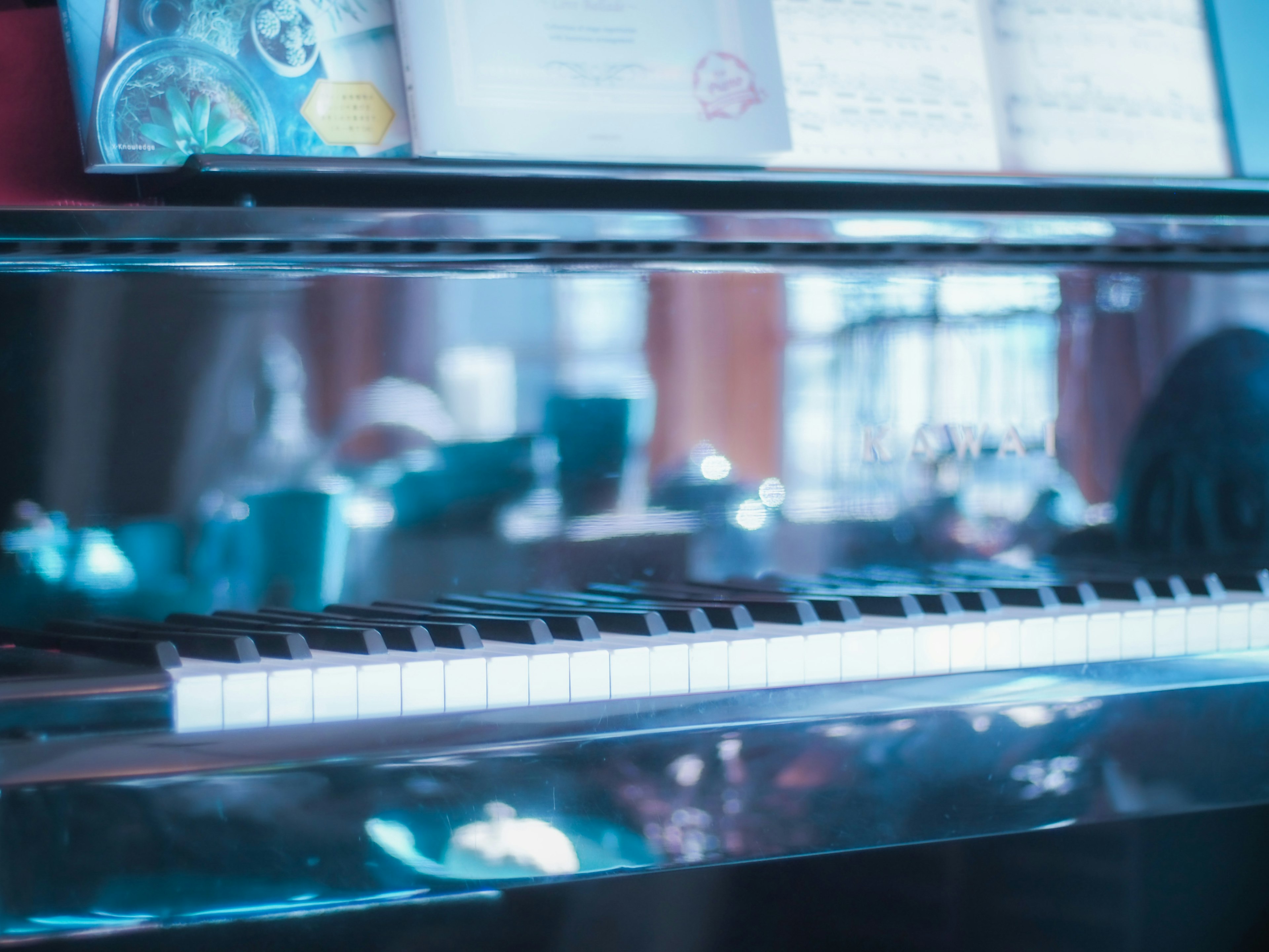 Clavier de piano reflétant une lumière bleue avec des partitions