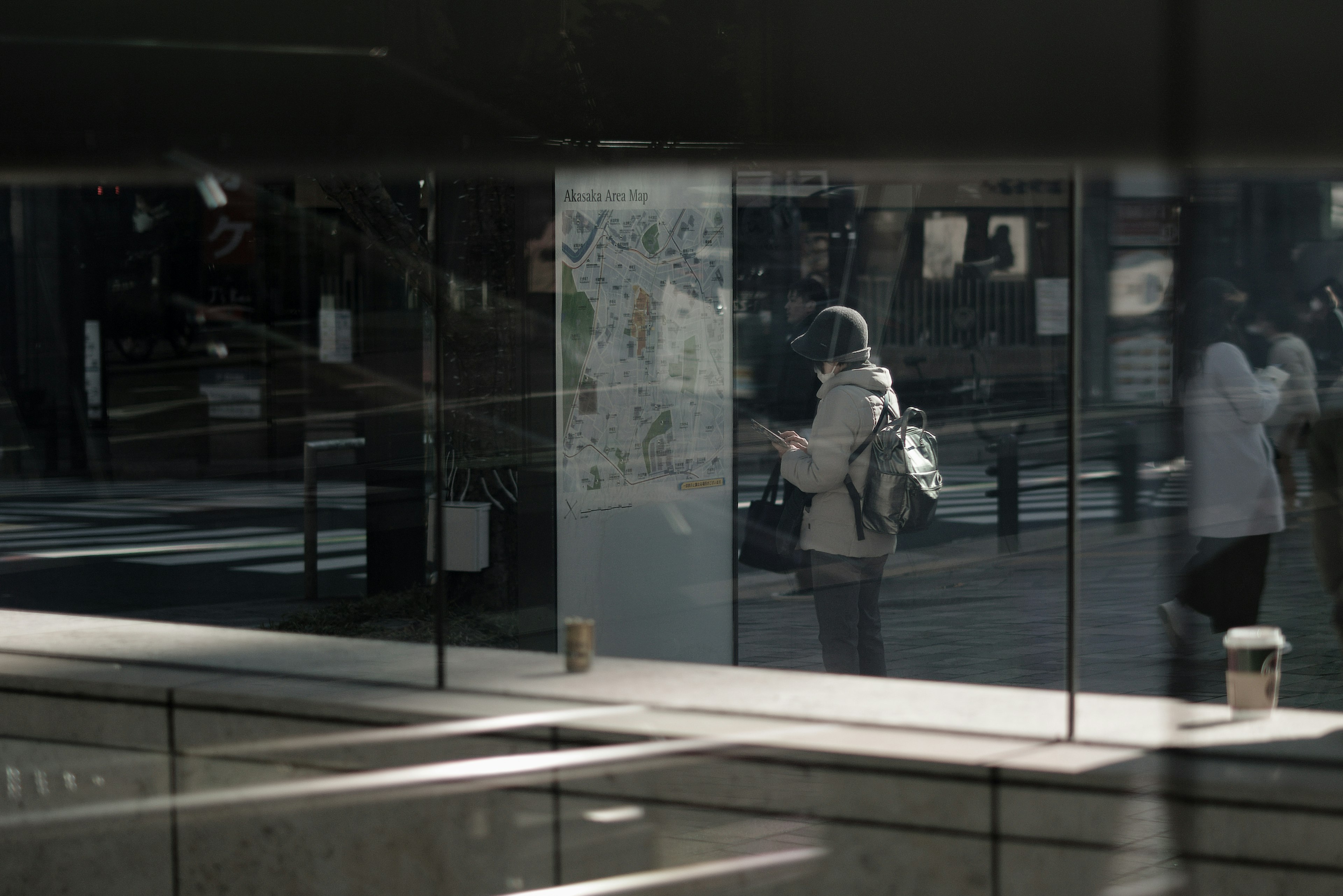 ガラスの反射に映る人々と街の風景