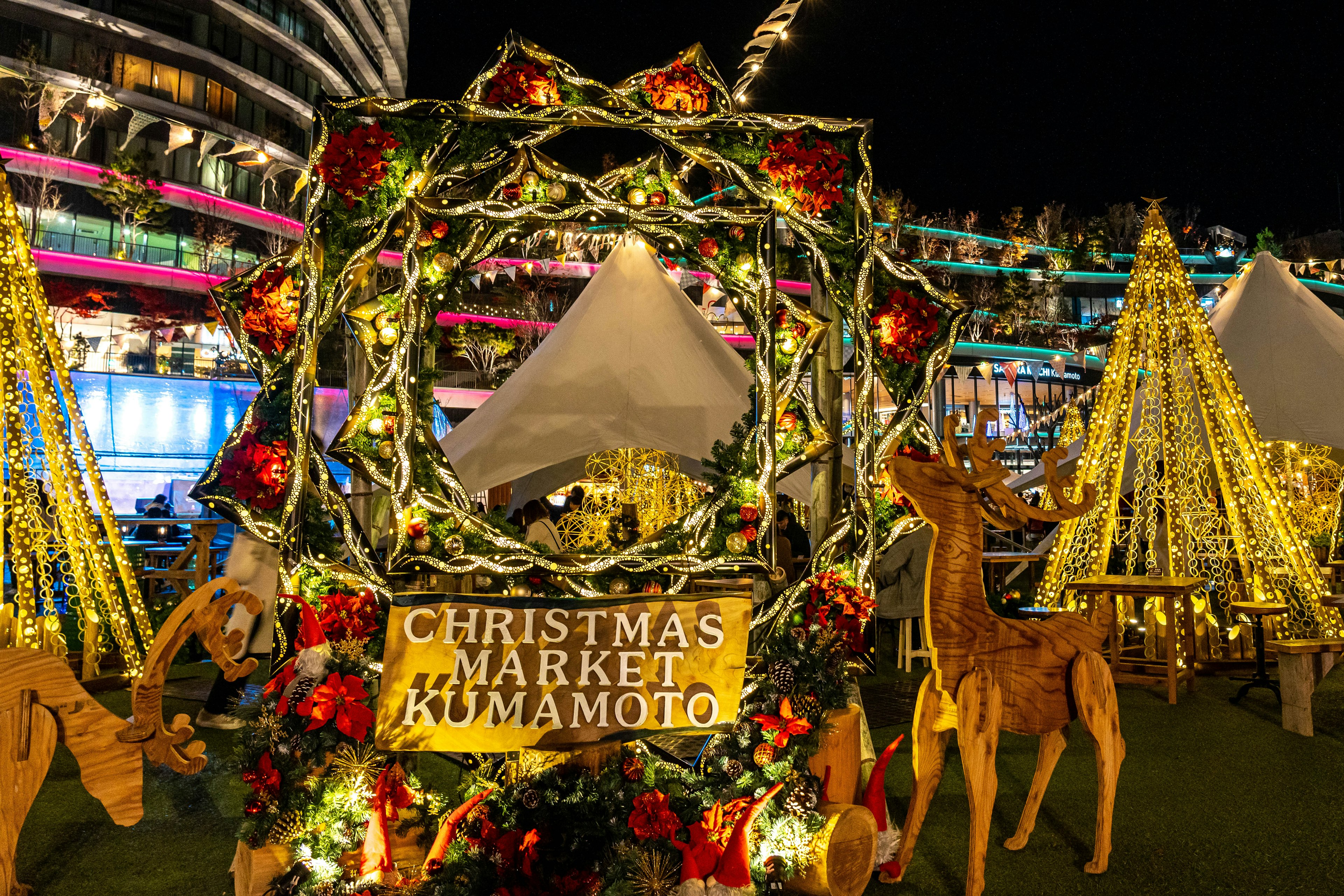 Vista nocturna del mercado navideño de Kumamoto con decoraciones festivas