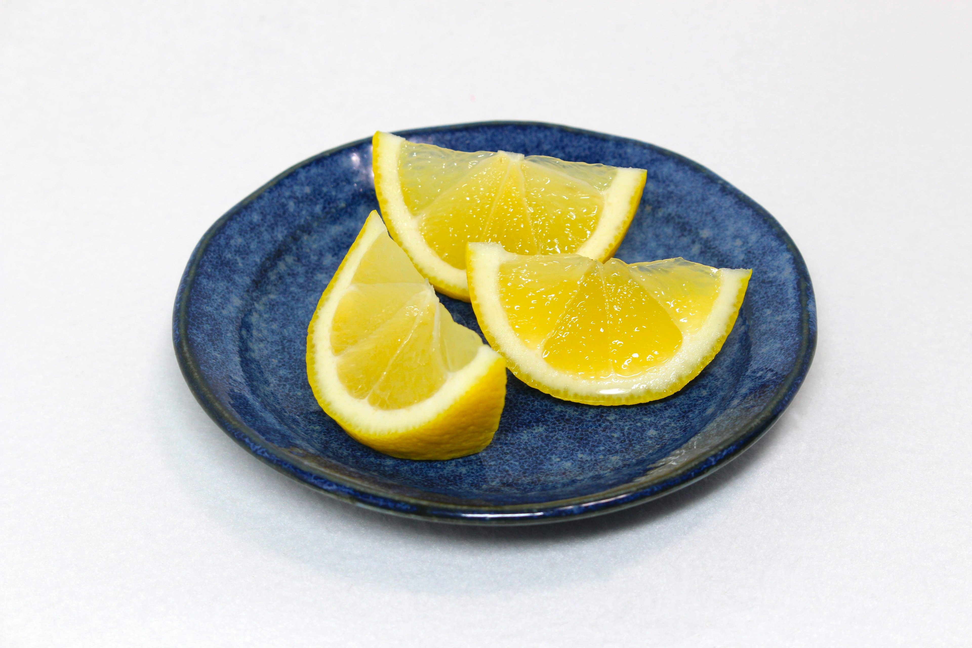 Tranches de citron frais sur une assiette bleue