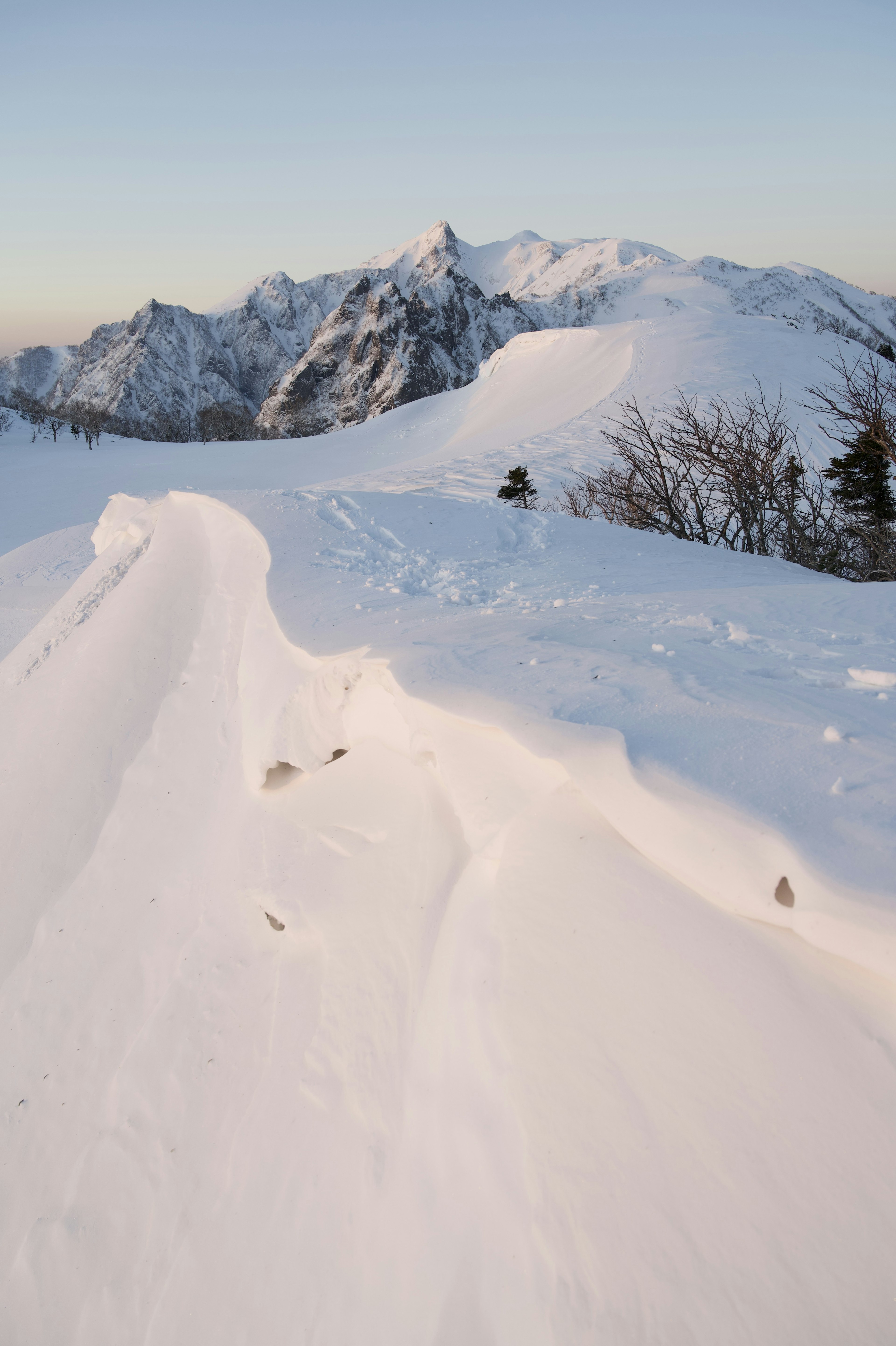 Paisaje montañoso cubierto de nieve con picos nevados a lo lejos