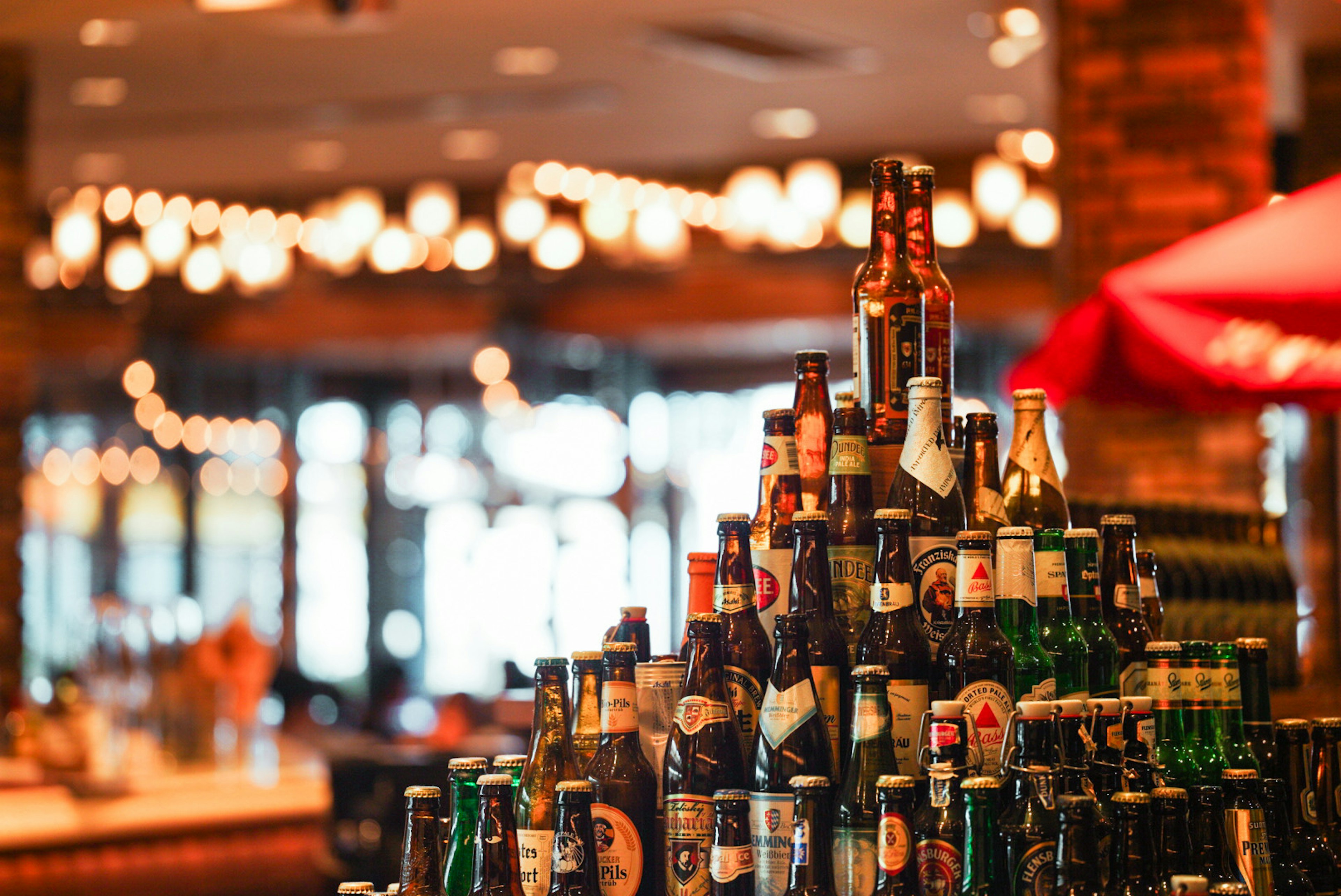 Un interior de bar vibrante con una pirámide de botellas de cerveza