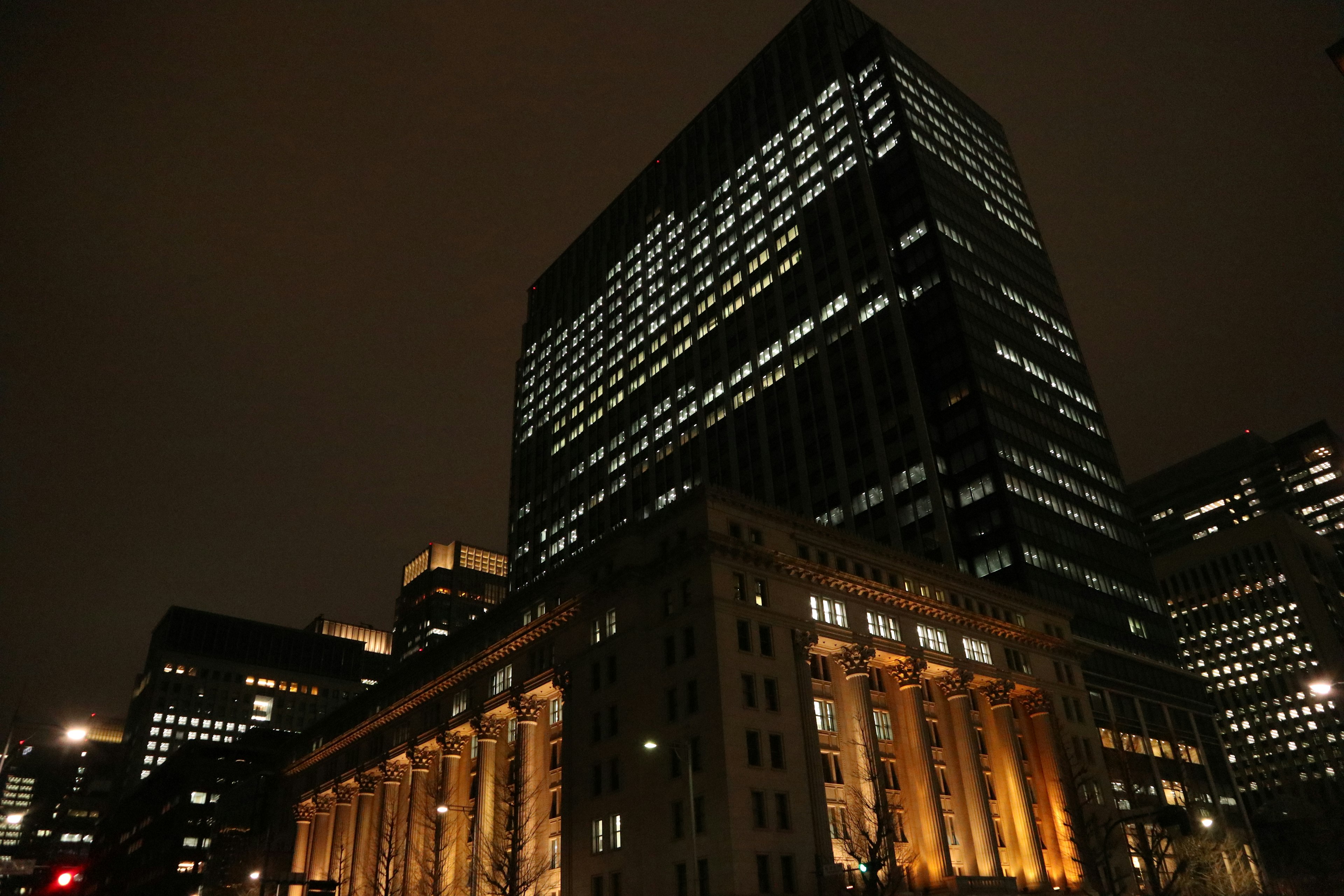 Paesaggio urbano notturno con un grattacielo moderno e un edificio storico