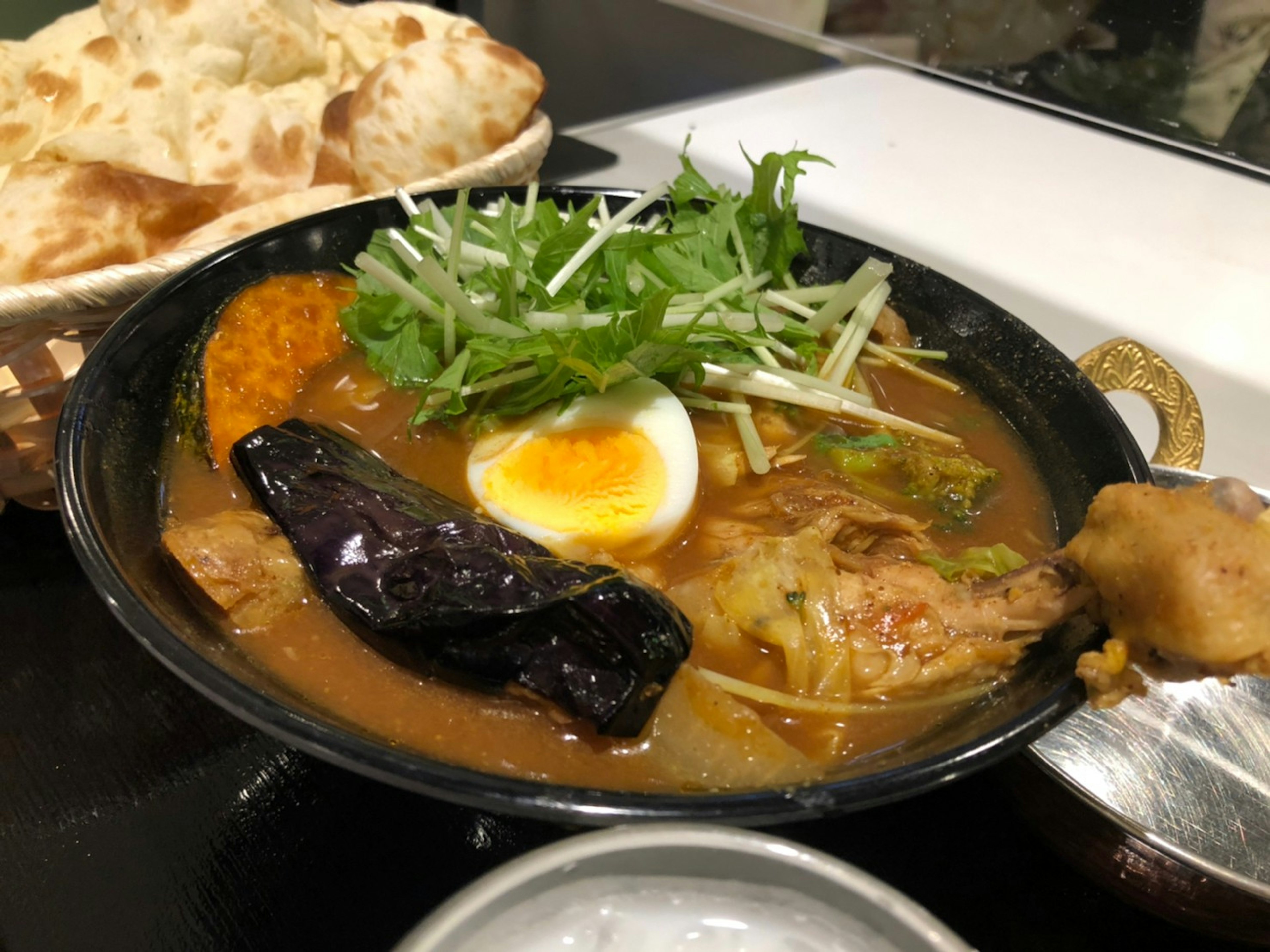 Delicious ramen bowl with tender chicken and soft boiled egg topped with fresh herbs