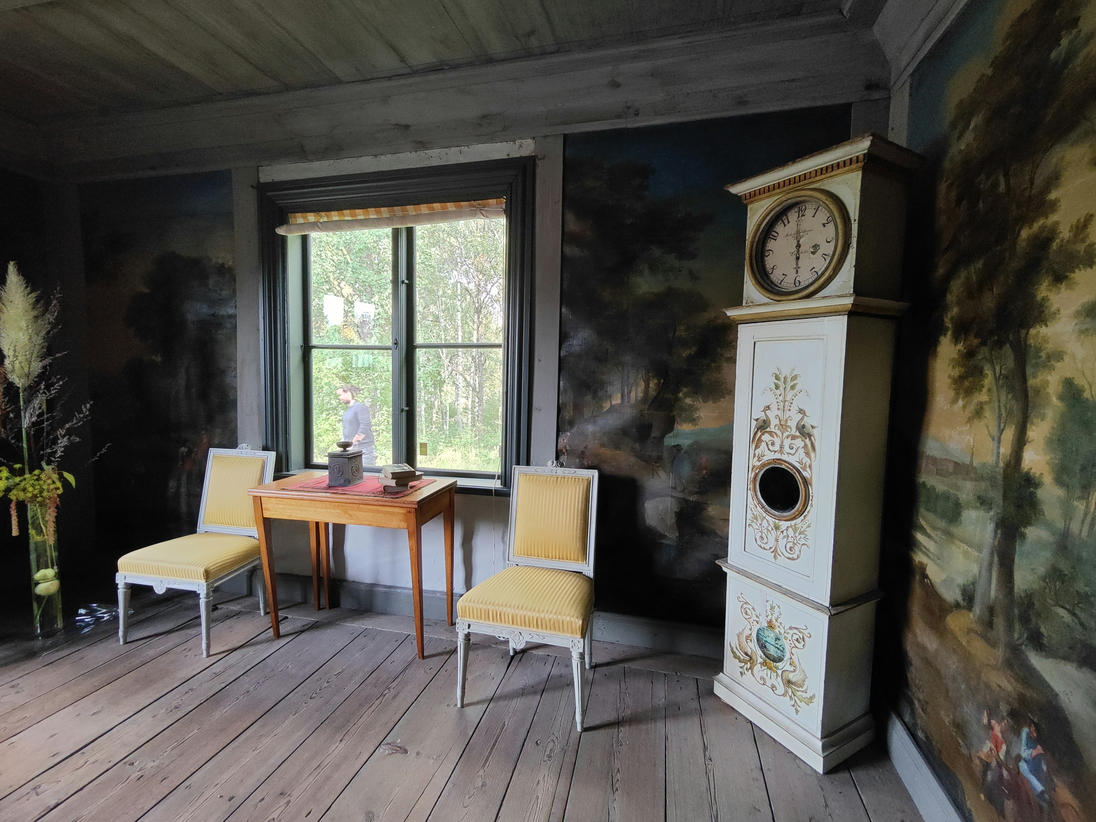 Une pièce vintage avec une table et des chaises Peintures murales pittoresques et une horloge proéminente