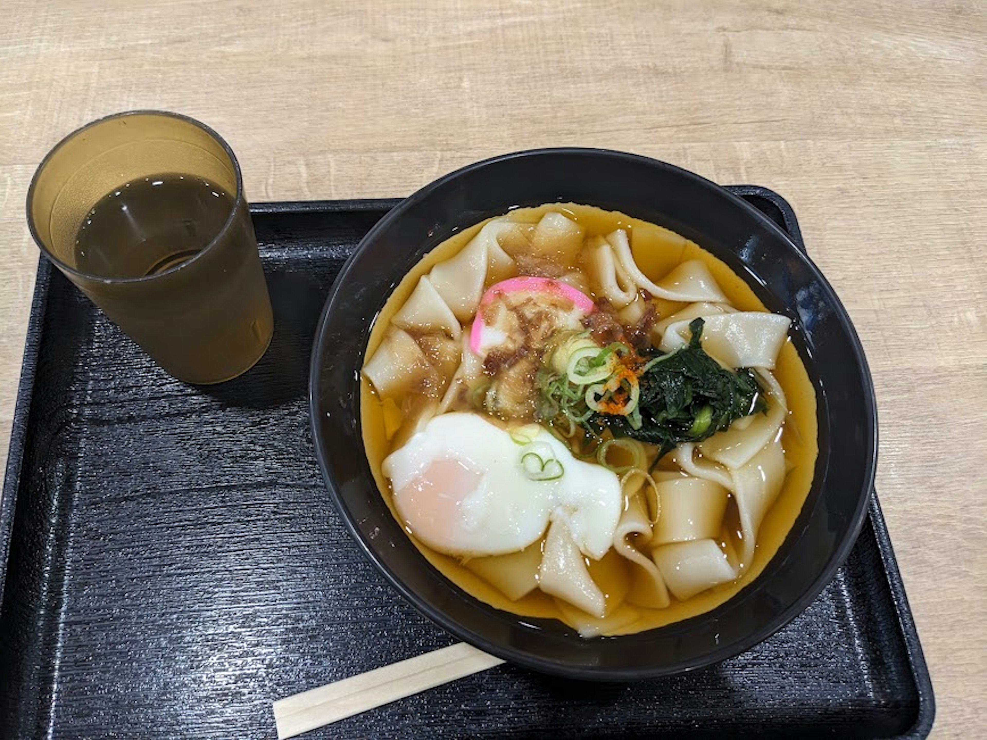 Mangkuk ramen hangat dengan toping dan segelas minuman