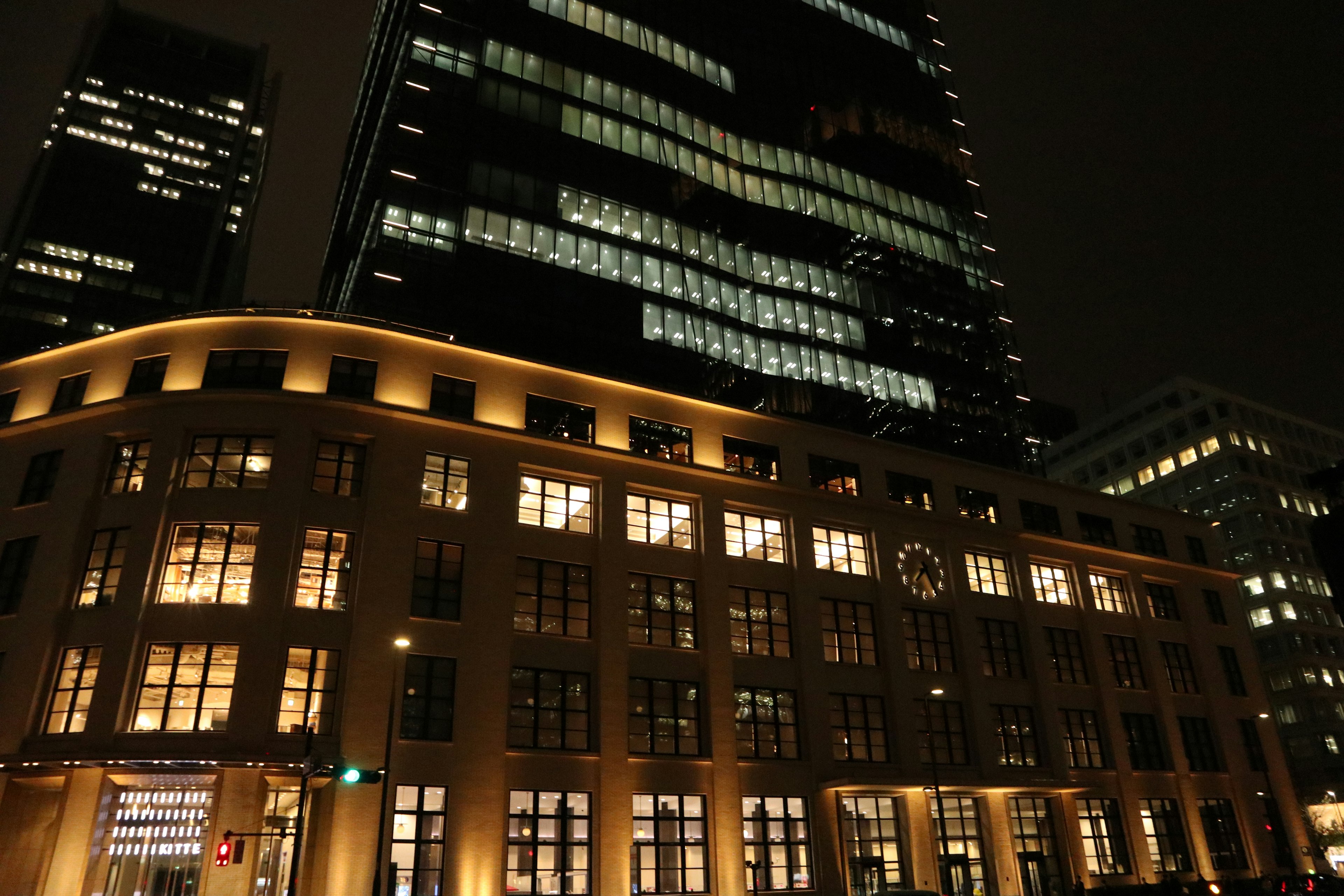 Night cityscape with towering skyscrapers and historic buildings