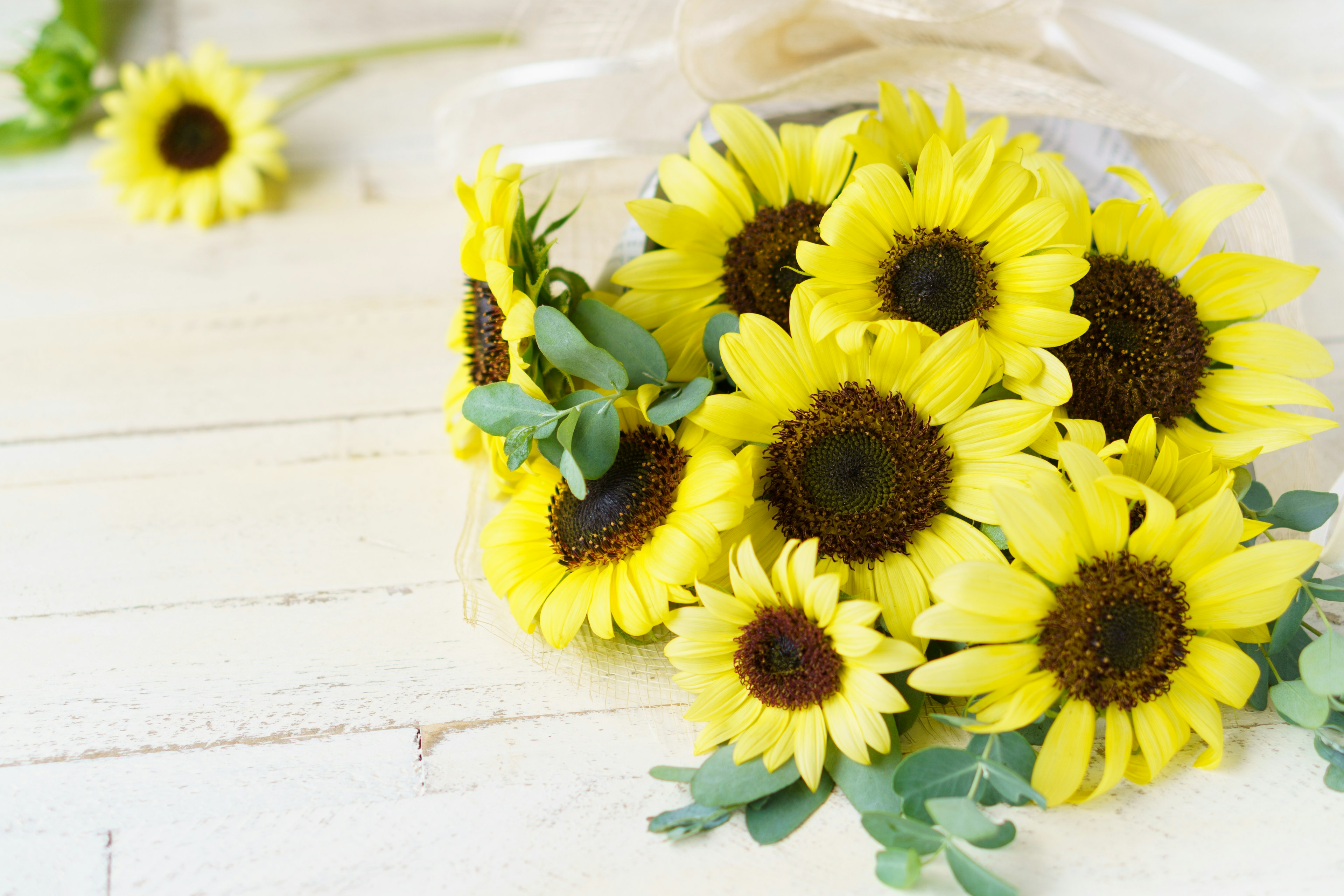 Un bouquet vibrant de tournesols posé sur une table en bois