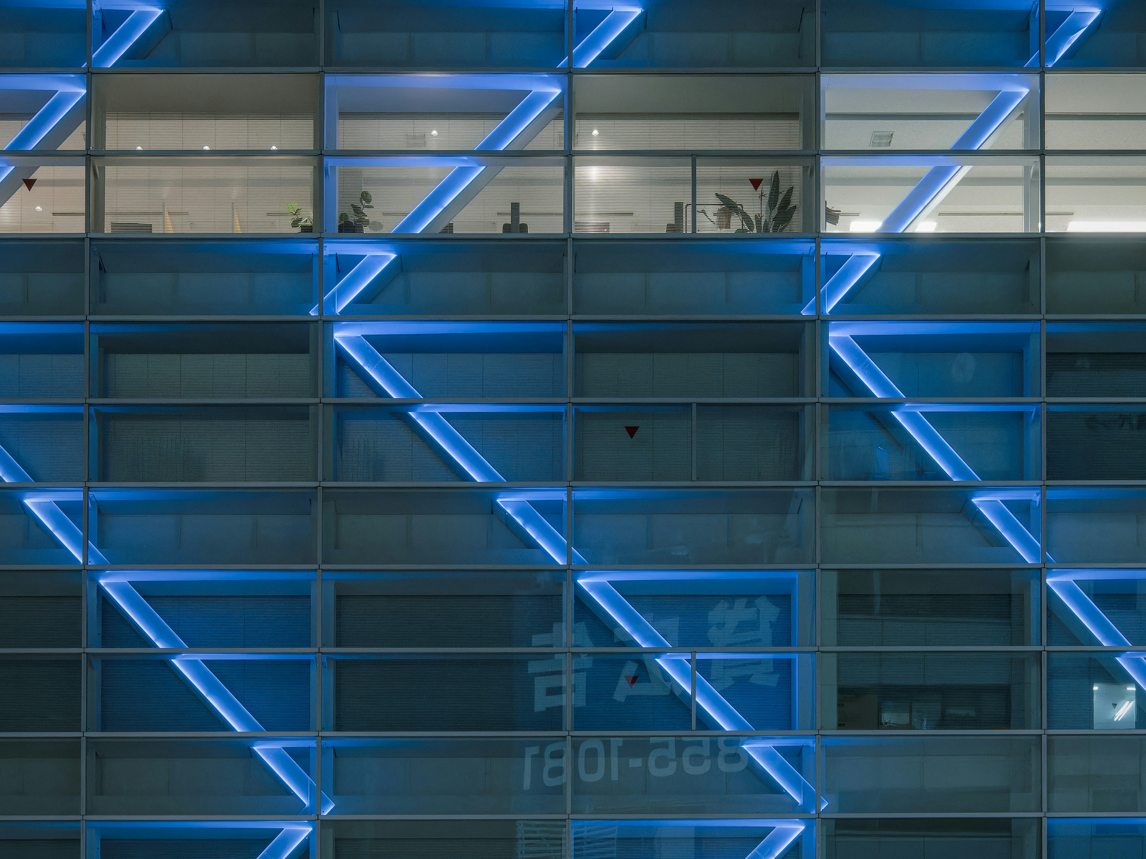 Facciata di un edificio moderno con illuminazione blu e motivi geometrici