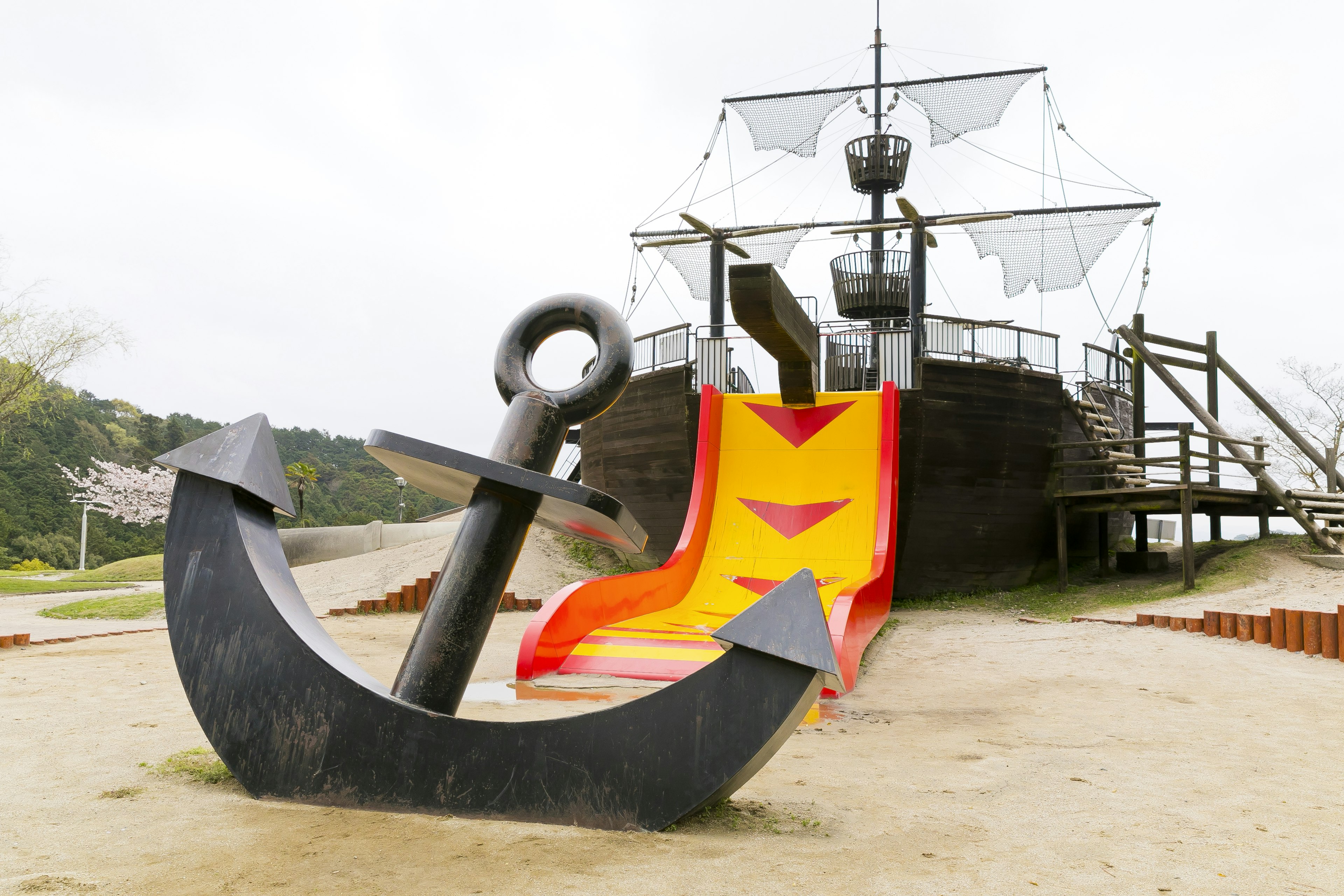 Terrain de jeu avec une structure de bateau pirate et un toboggan