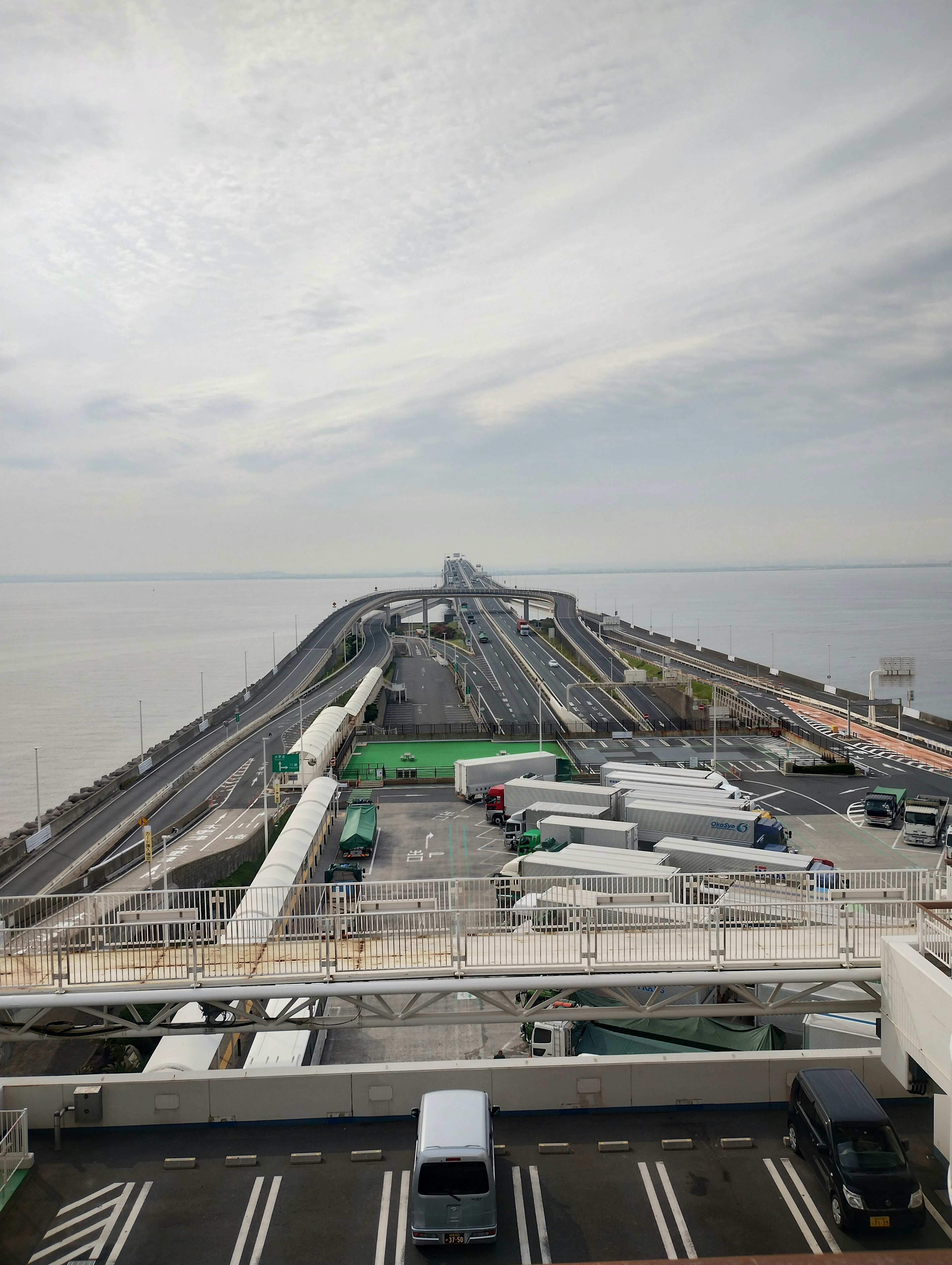 Wide road with trucks alongside the ocean