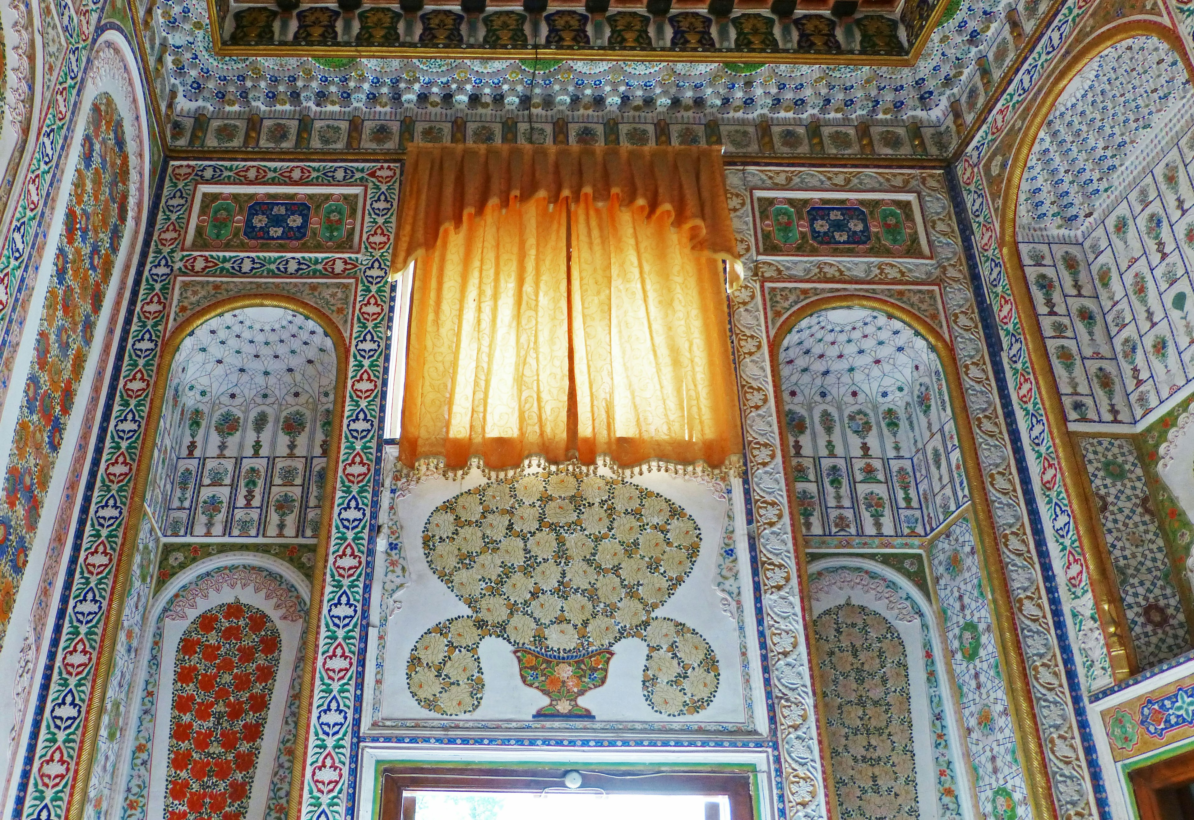 Interior of a room with vibrant decorations intricate patterns and an orange curtain