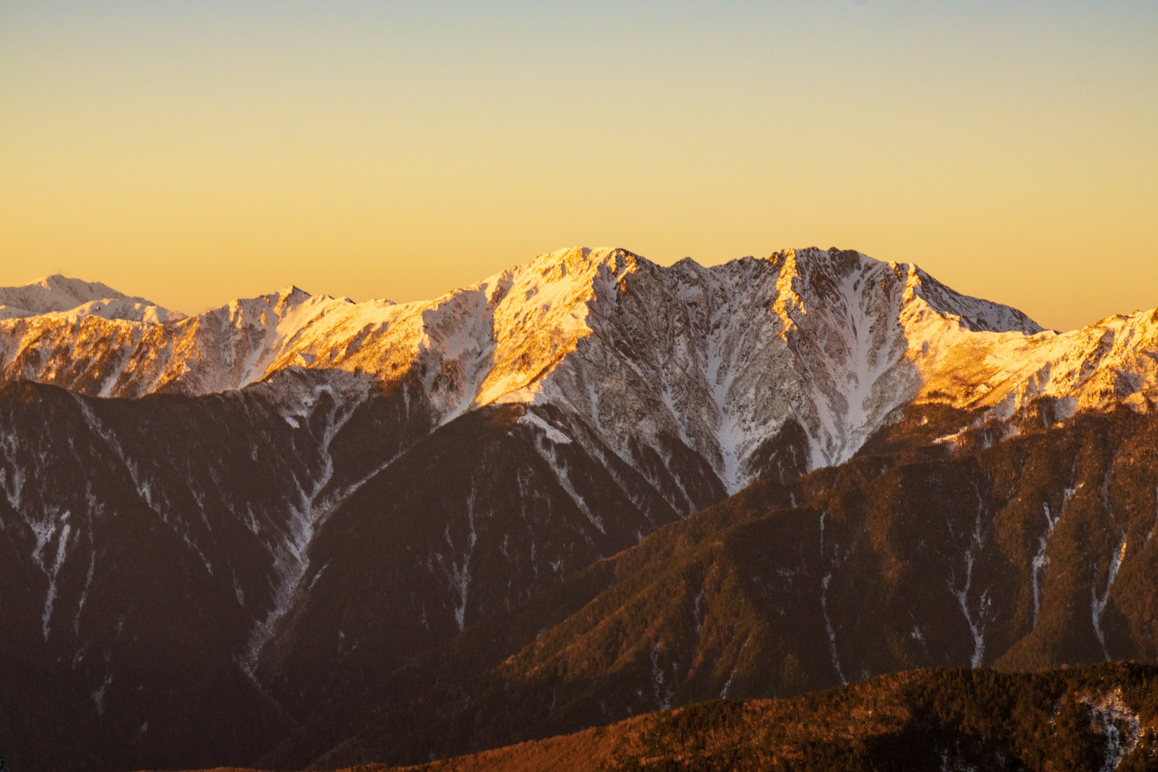 Snow-covered mountains illuminated by sunset