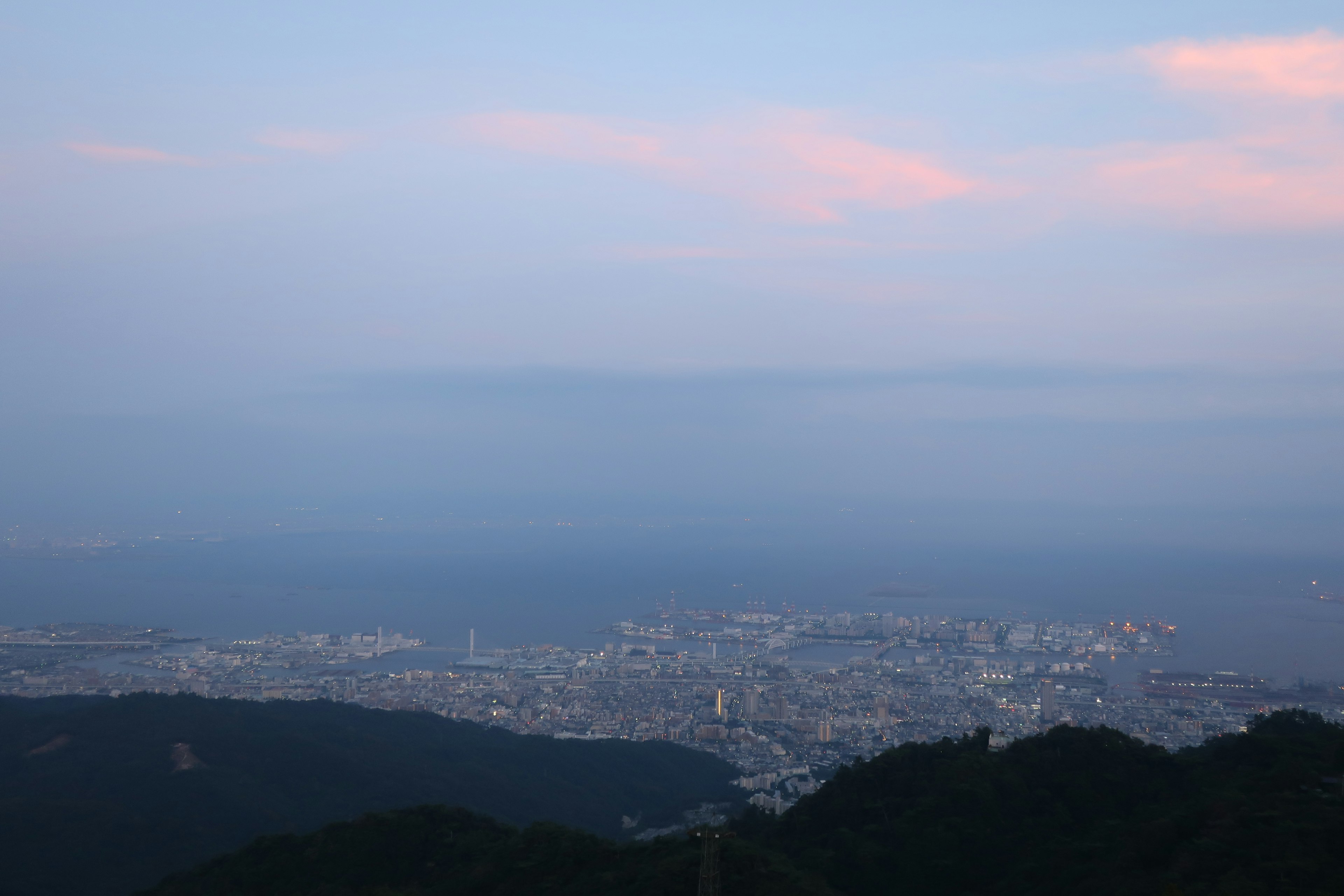 Panoramic view of the sea and city at dusk from a mountain