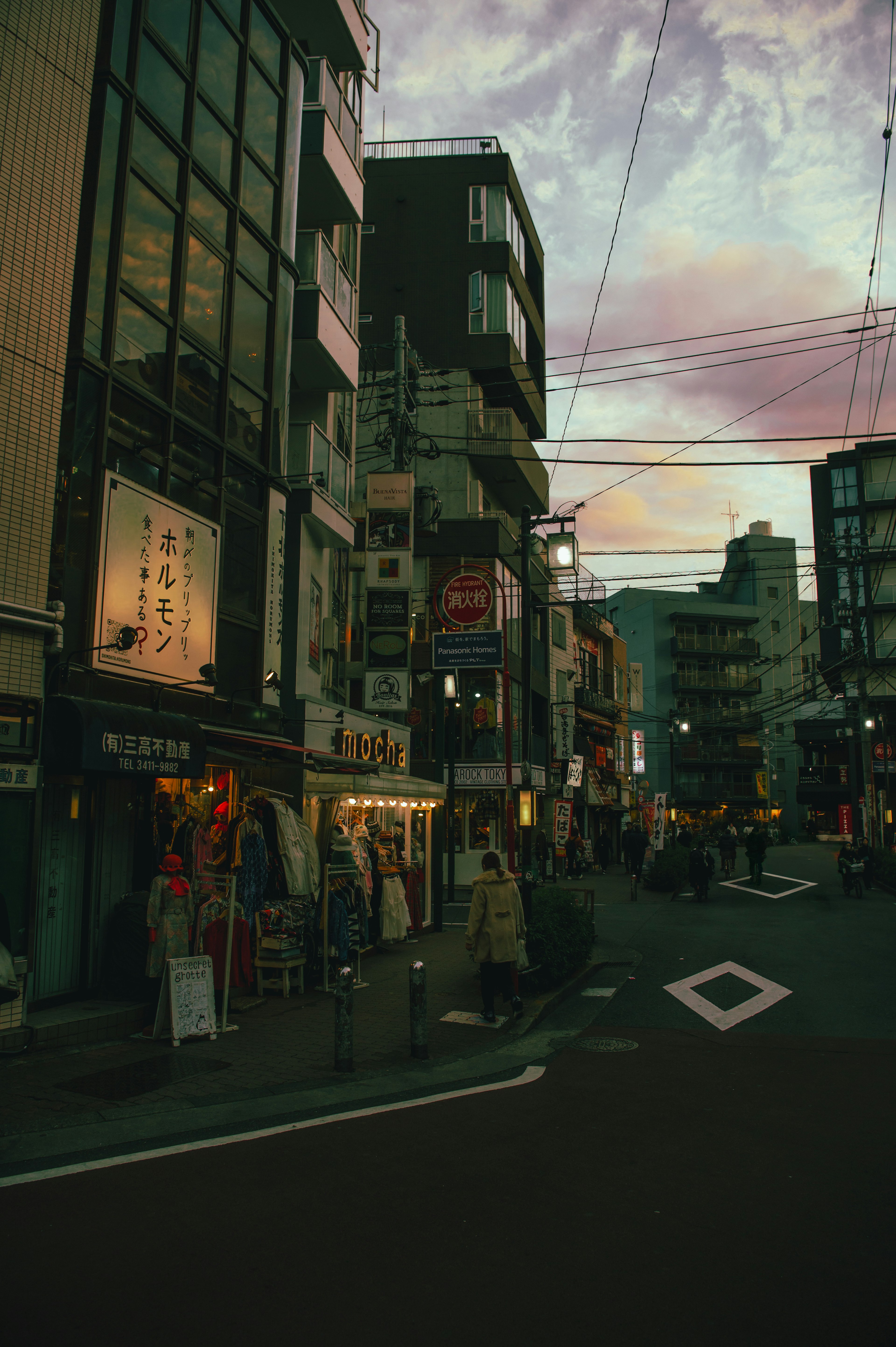 夕暮れ時の都市風景 店舗と看板が並ぶ通り