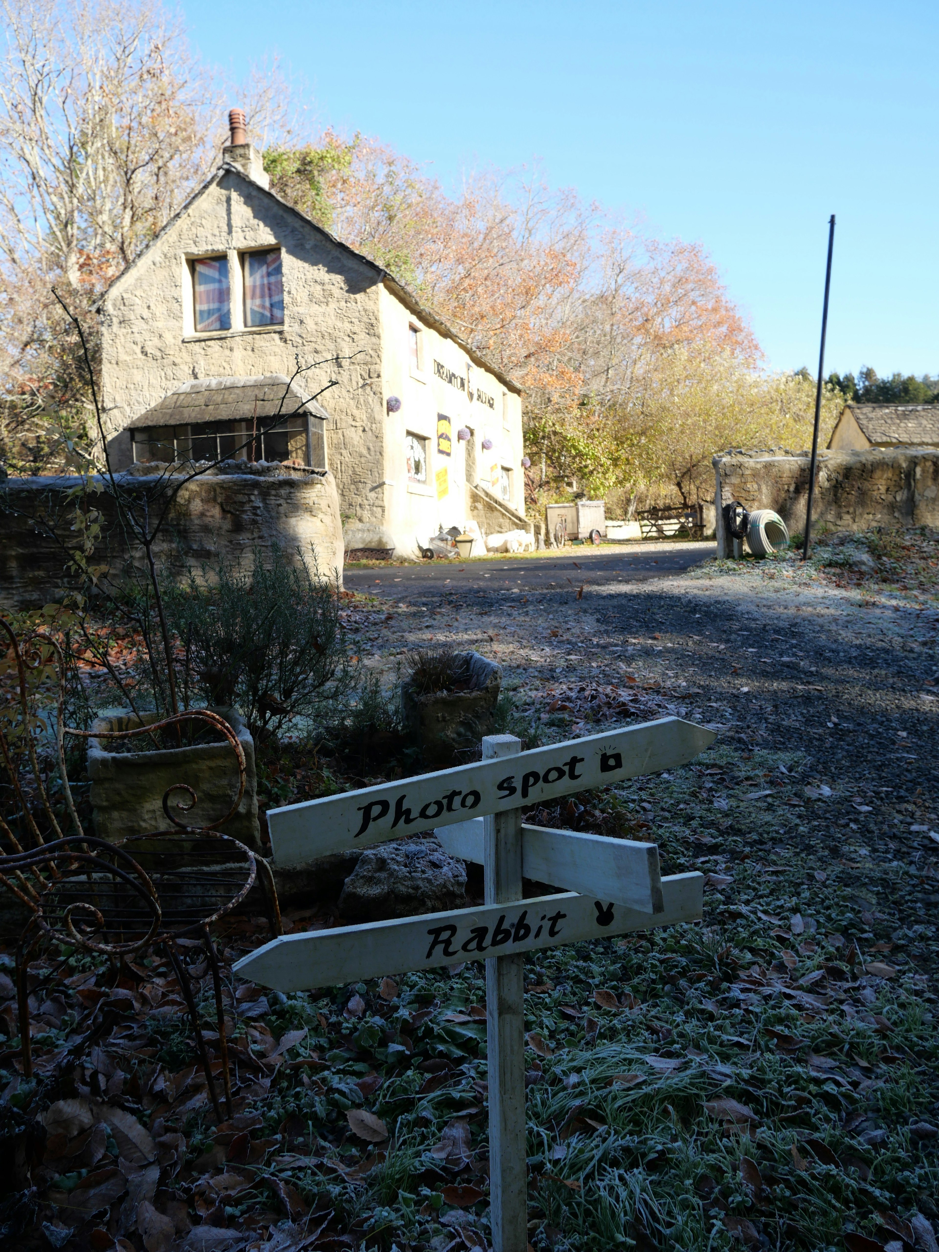 Une maison en pierre dans une scène tranquille d'hiver avec des panneaux directionnels