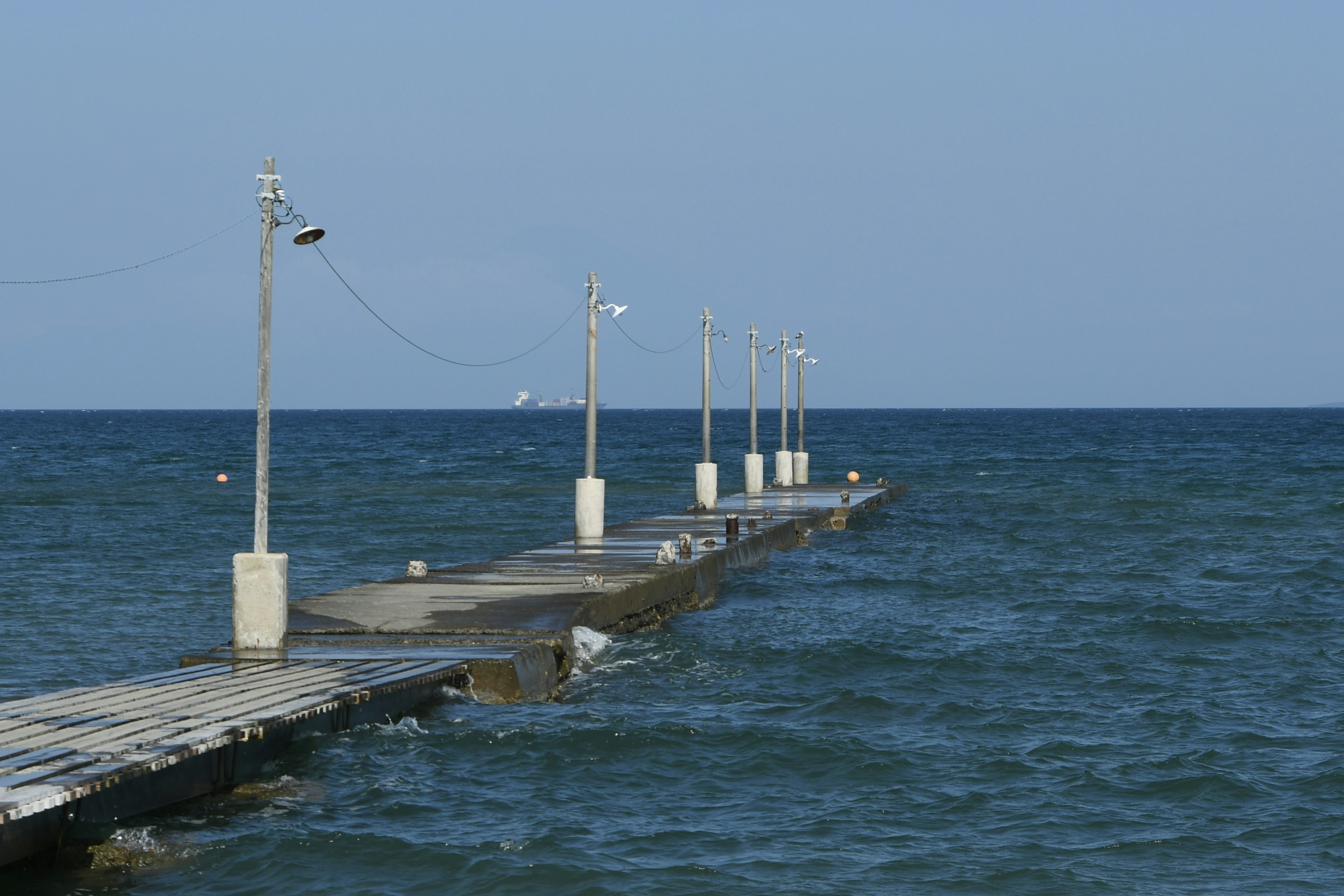 Ein langer Steg, der in das bewegte Meer führt