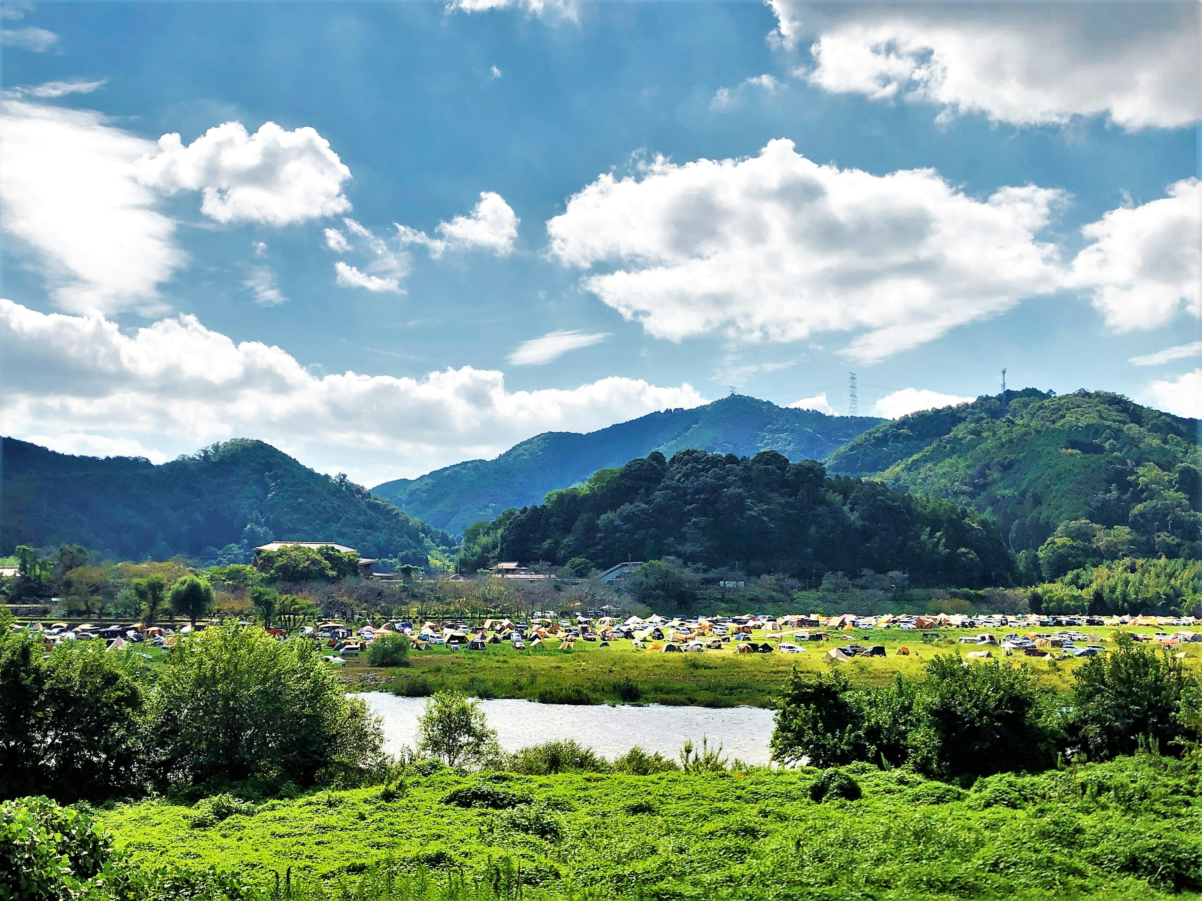 Paysage avec ciel bleu et nuages blancs montagnes verdoyantes et une rivière