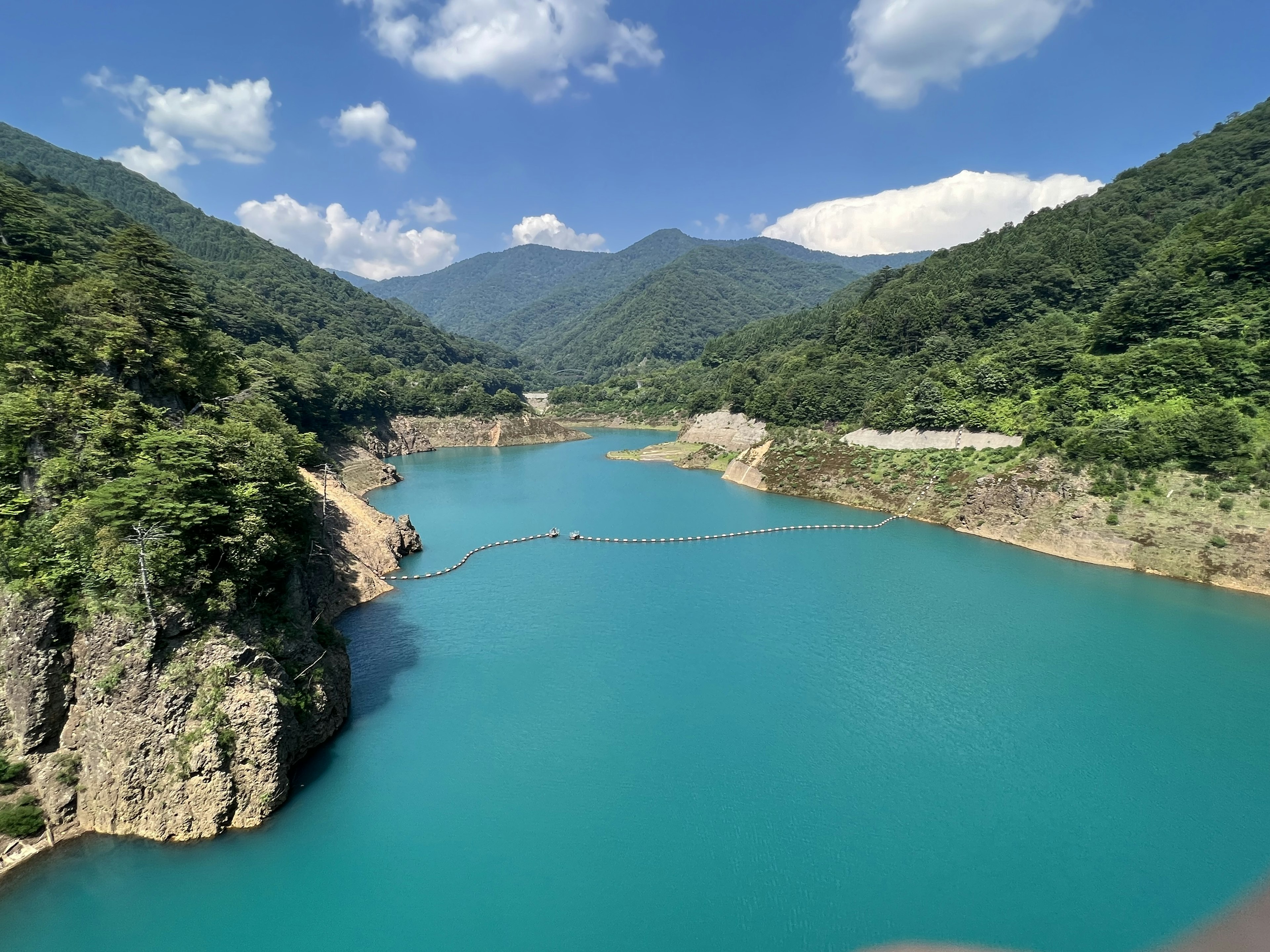 Scenic view of turquoise lake surrounded by lush green mountains