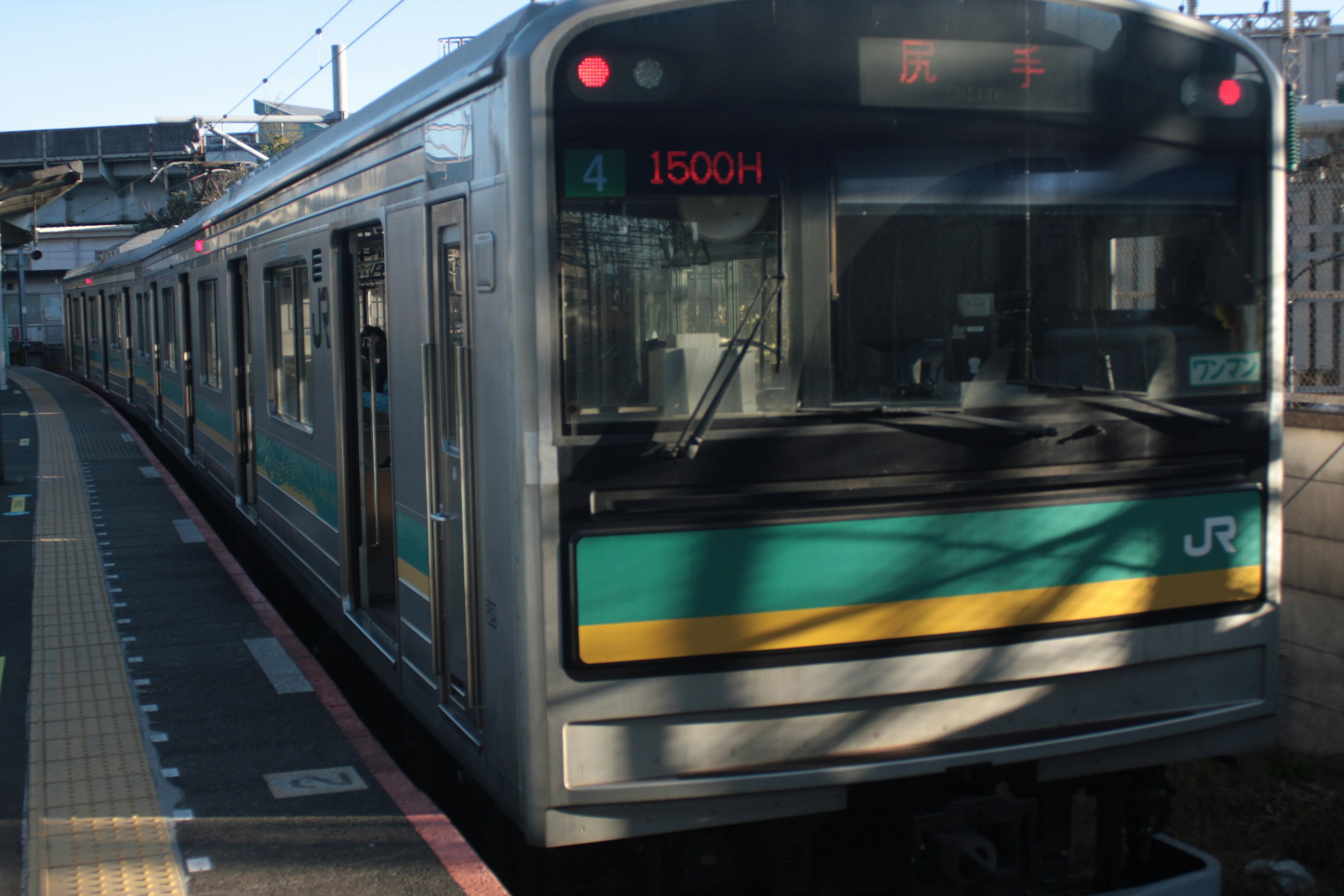 緑と銀のJR電車が駅に停車中