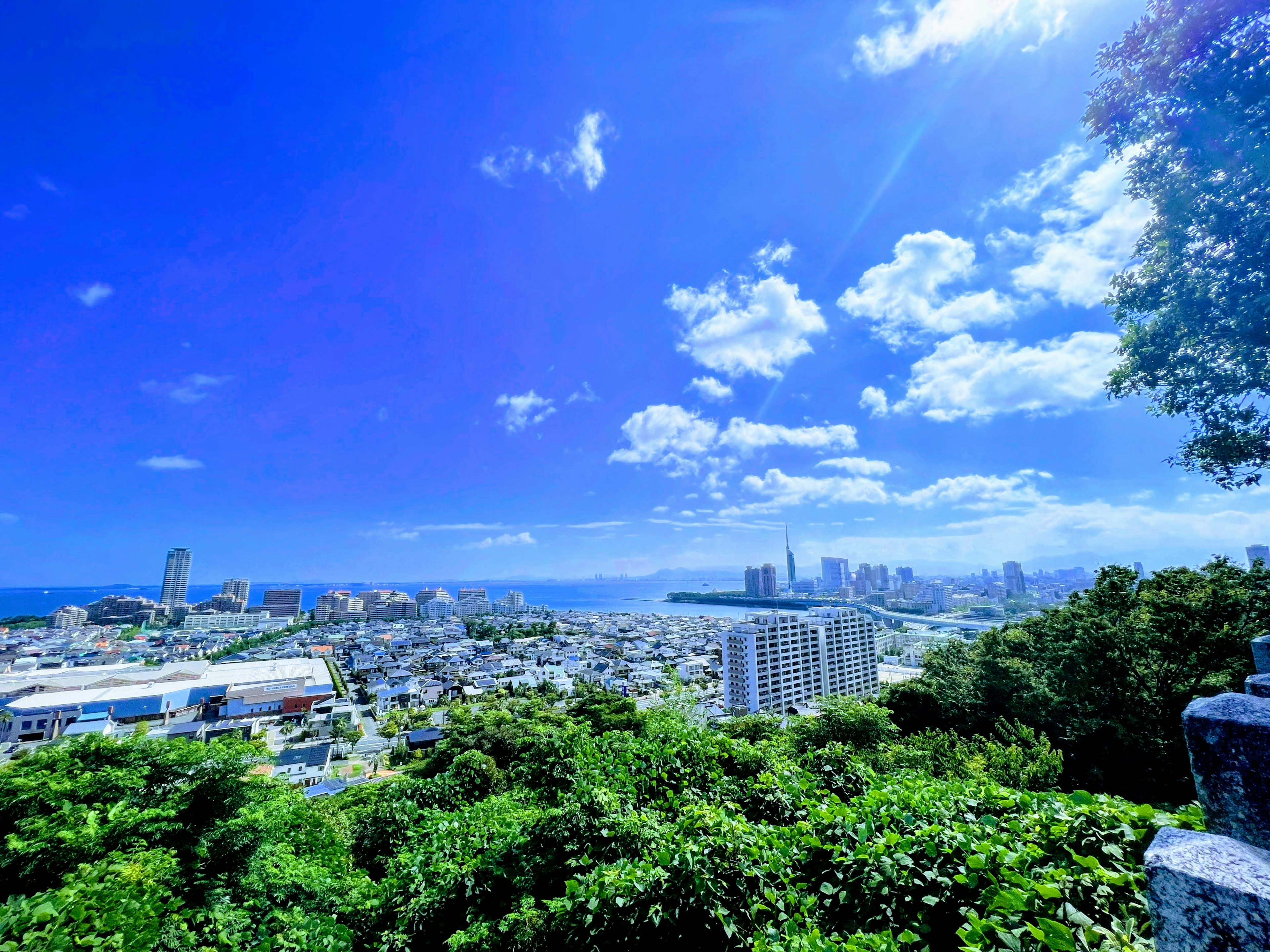 Hermoso paisaje urbano con cielo azul y nubes árboles verdes y mar visible