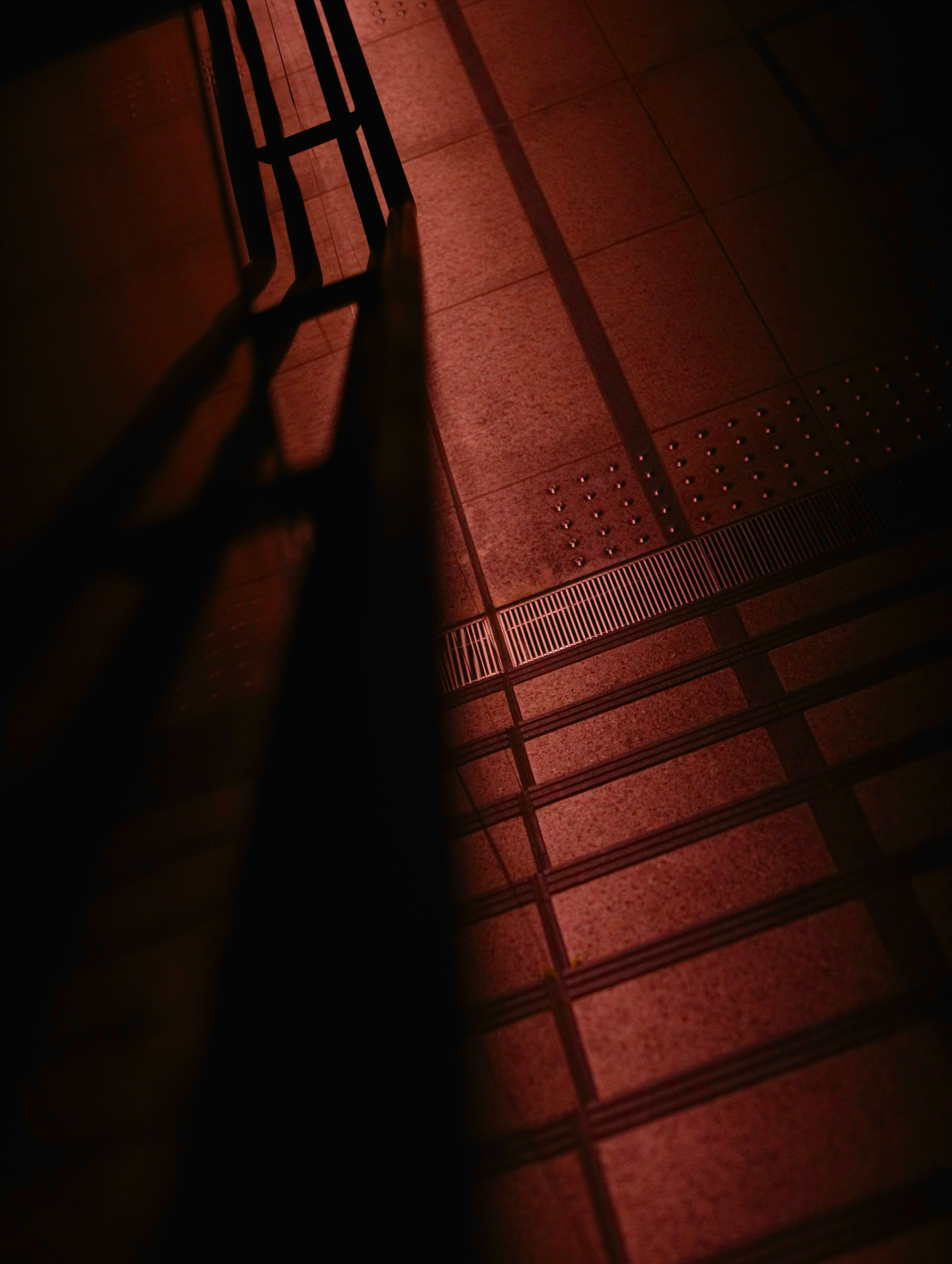 Photo featuring a dark red floor with striking shadow contrasts