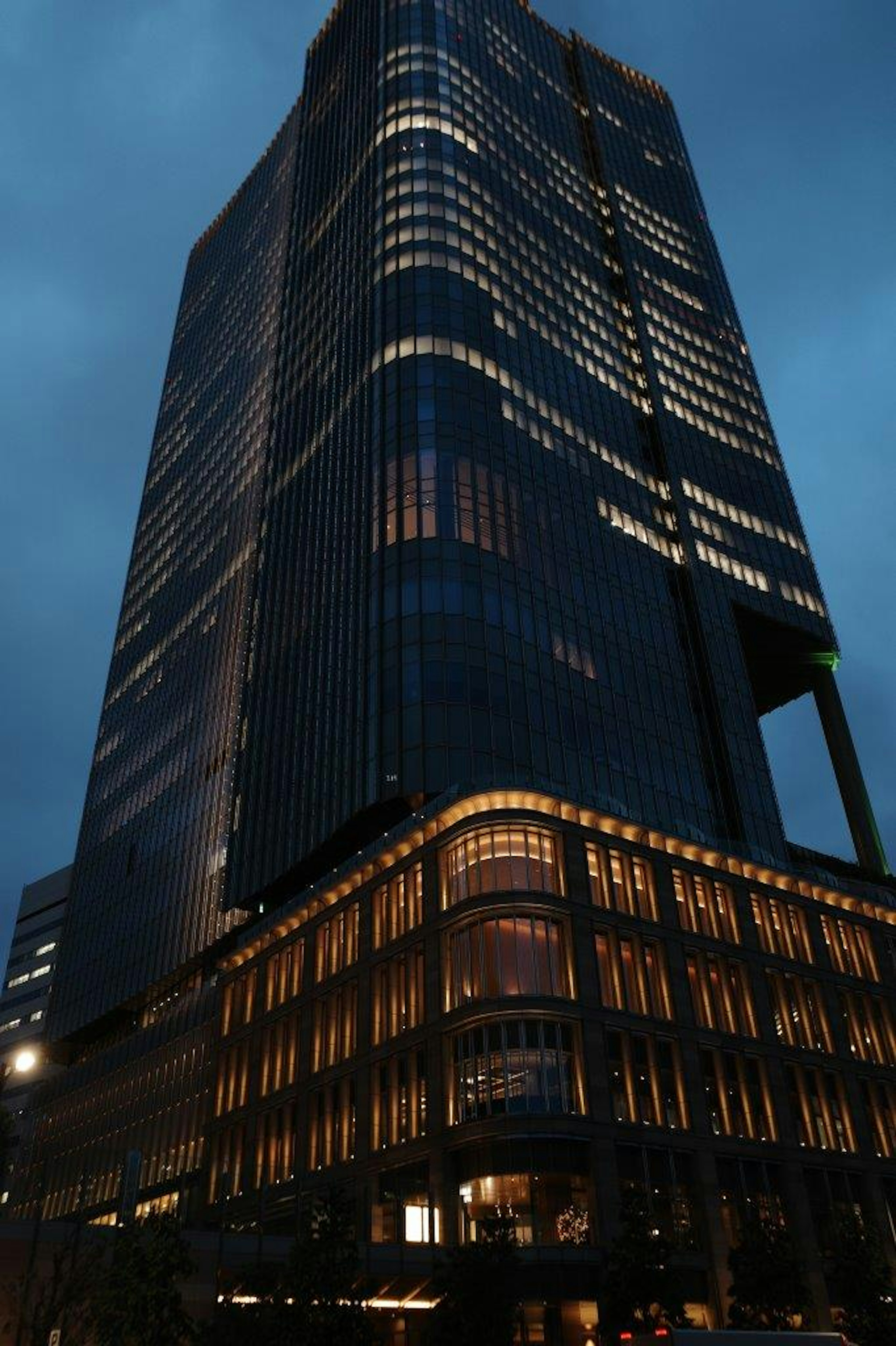 Modern skyscraper illuminated at night with unique architectural features