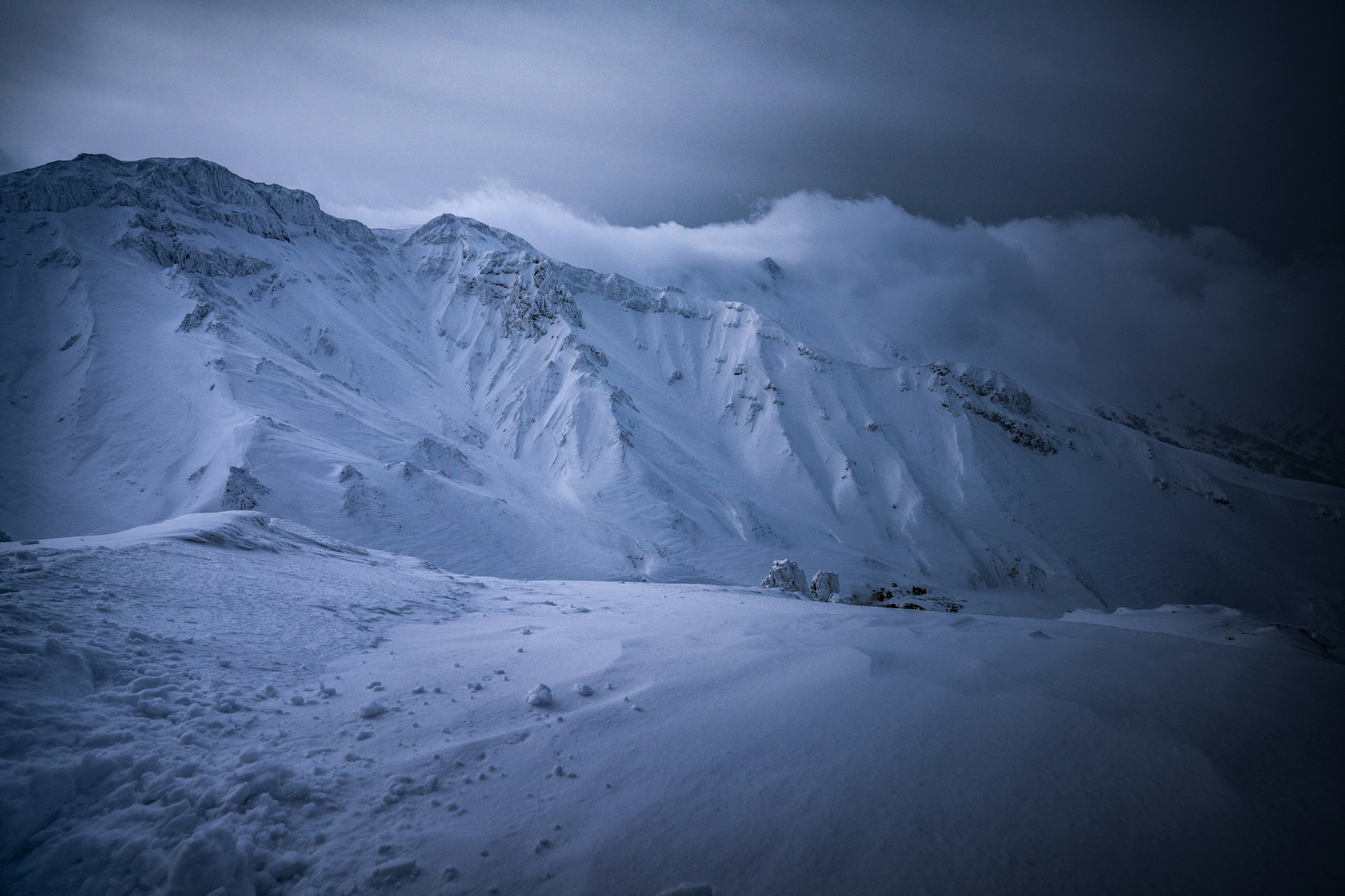 雪に覆われた山々と曇った空の風景