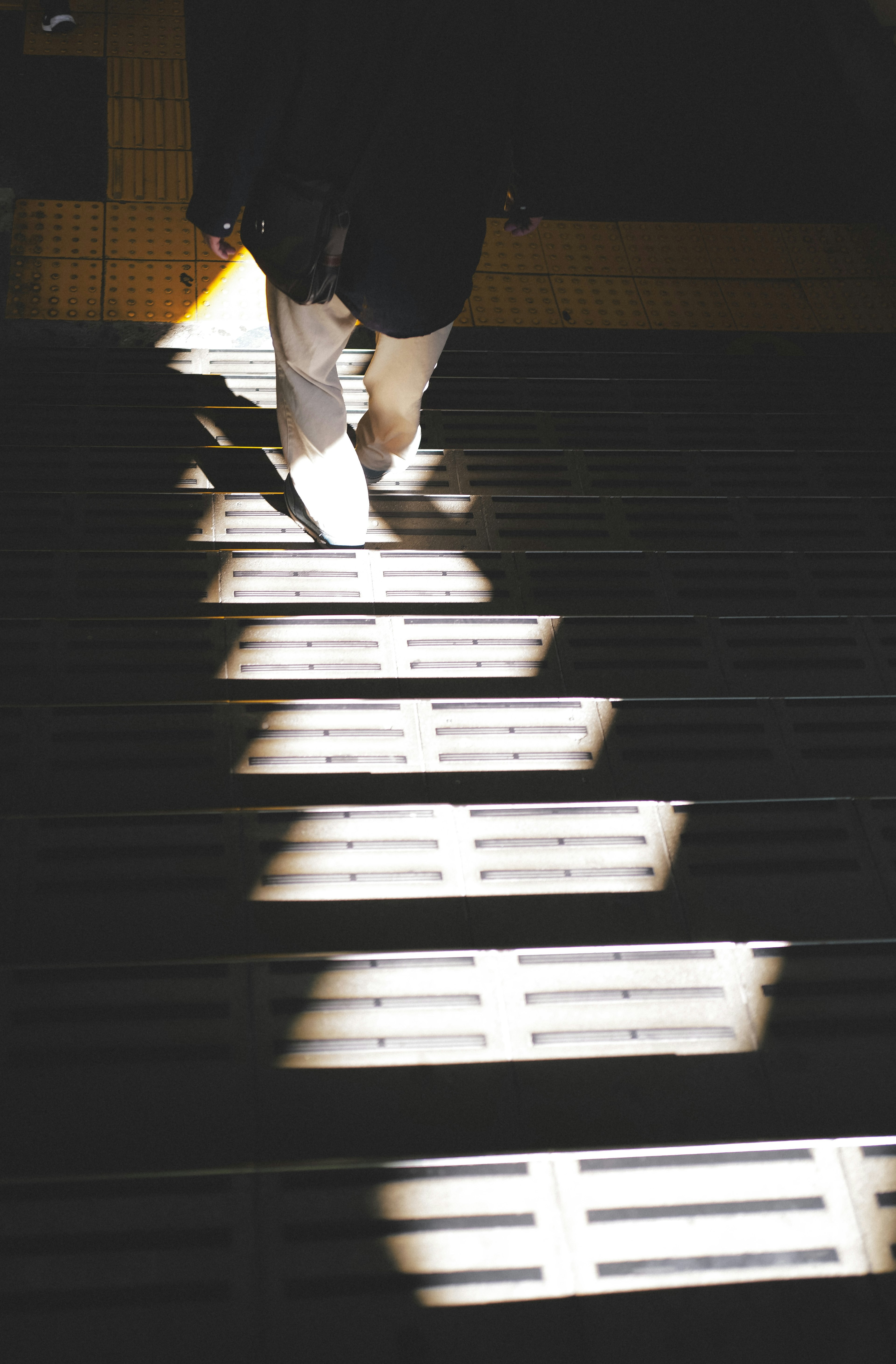 Persona subiendo escaleras iluminadas por la luz