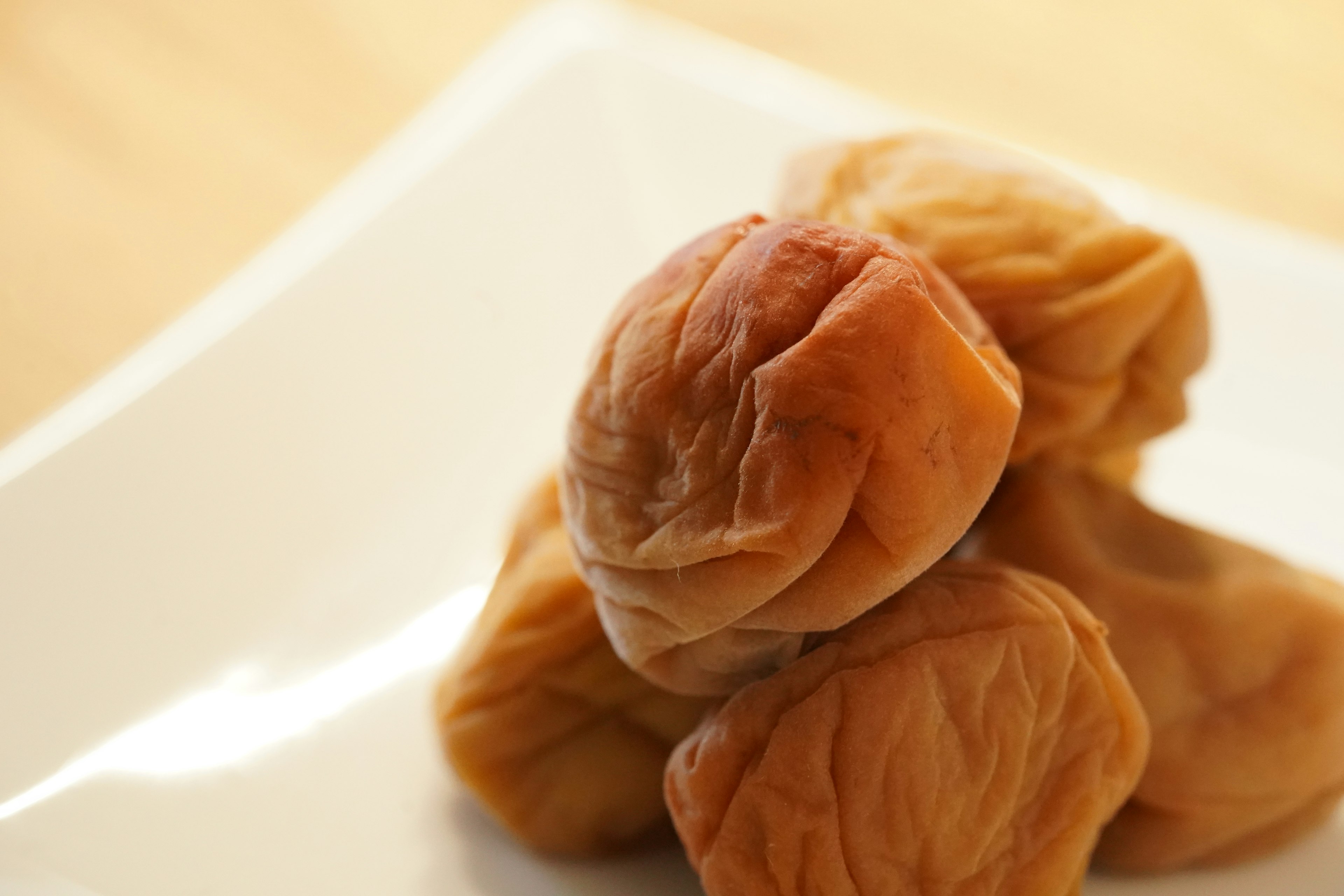 A pile of dried plums on a white plate