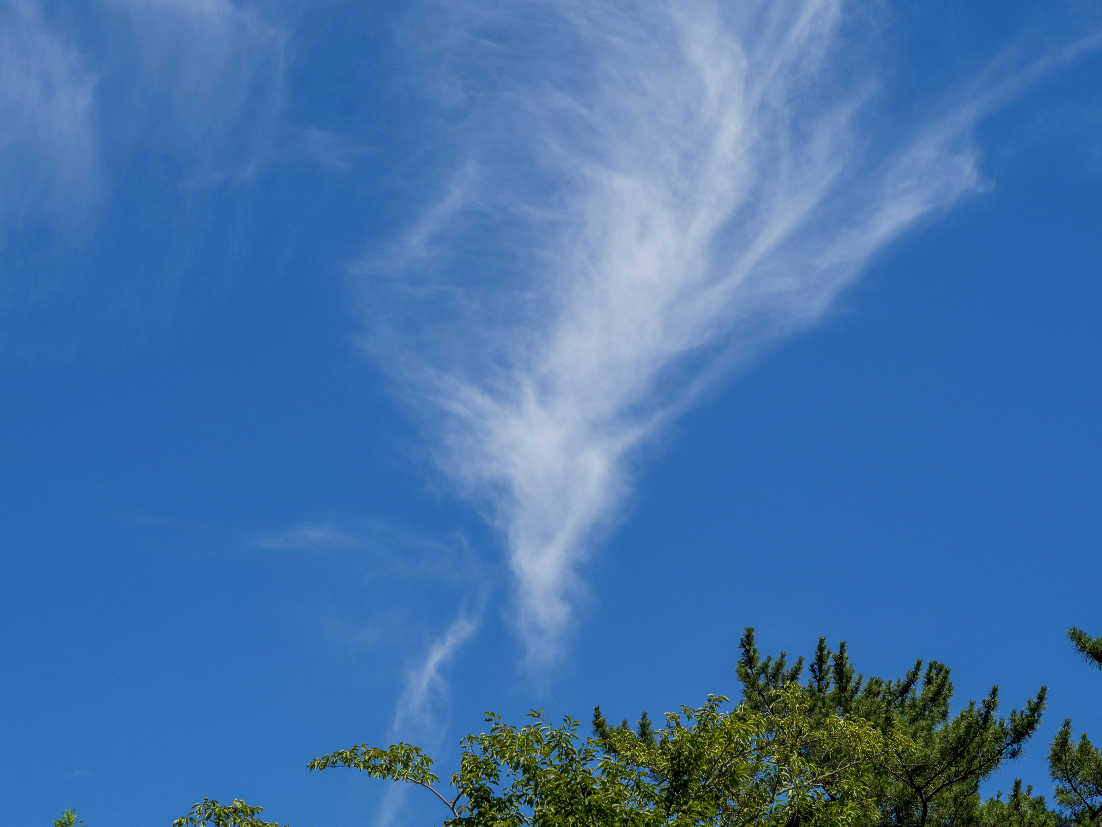 Awan putih berputar di latar belakang langit biru cerah