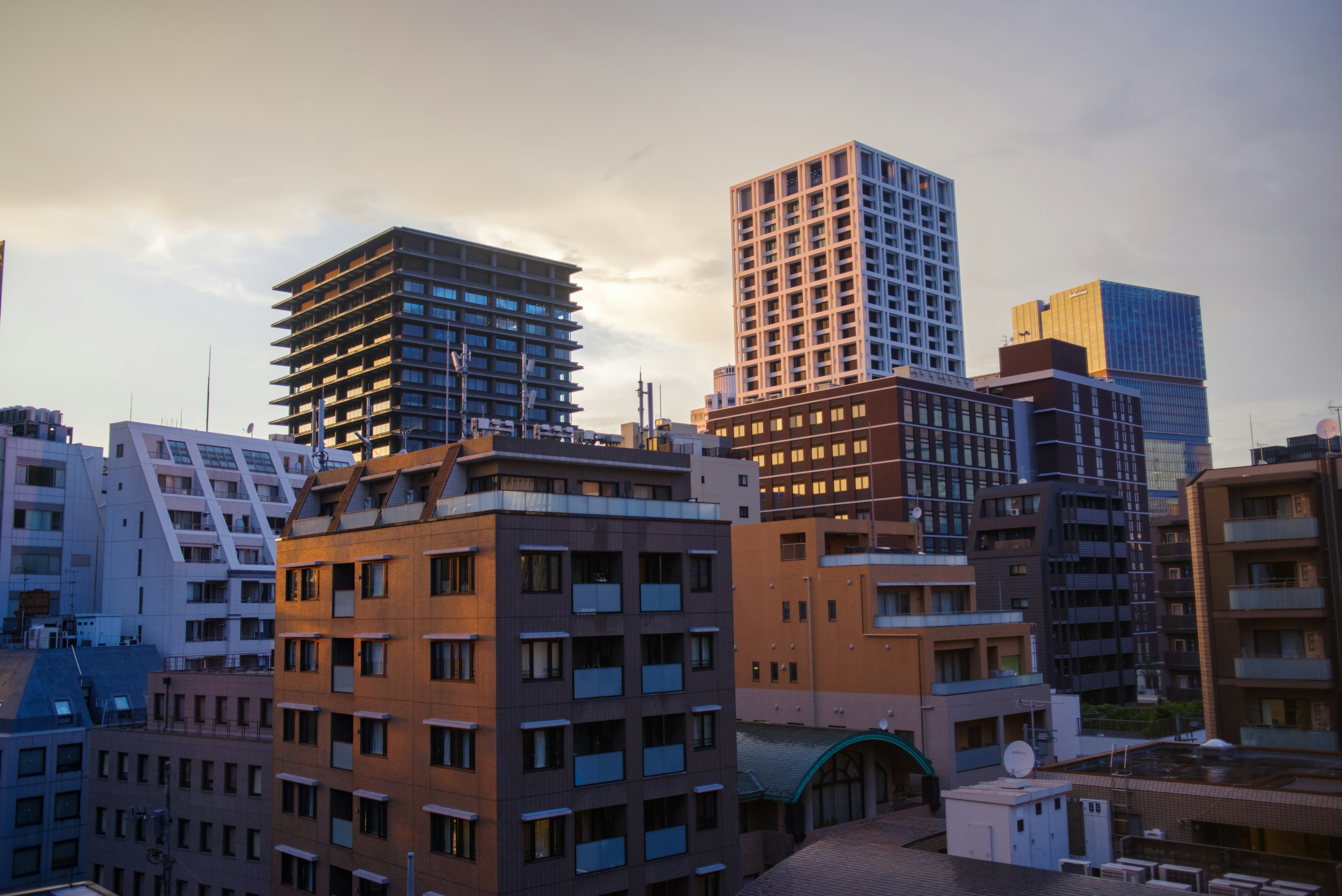 Urban skyline during sunset with a mix of high-rise and residential buildings