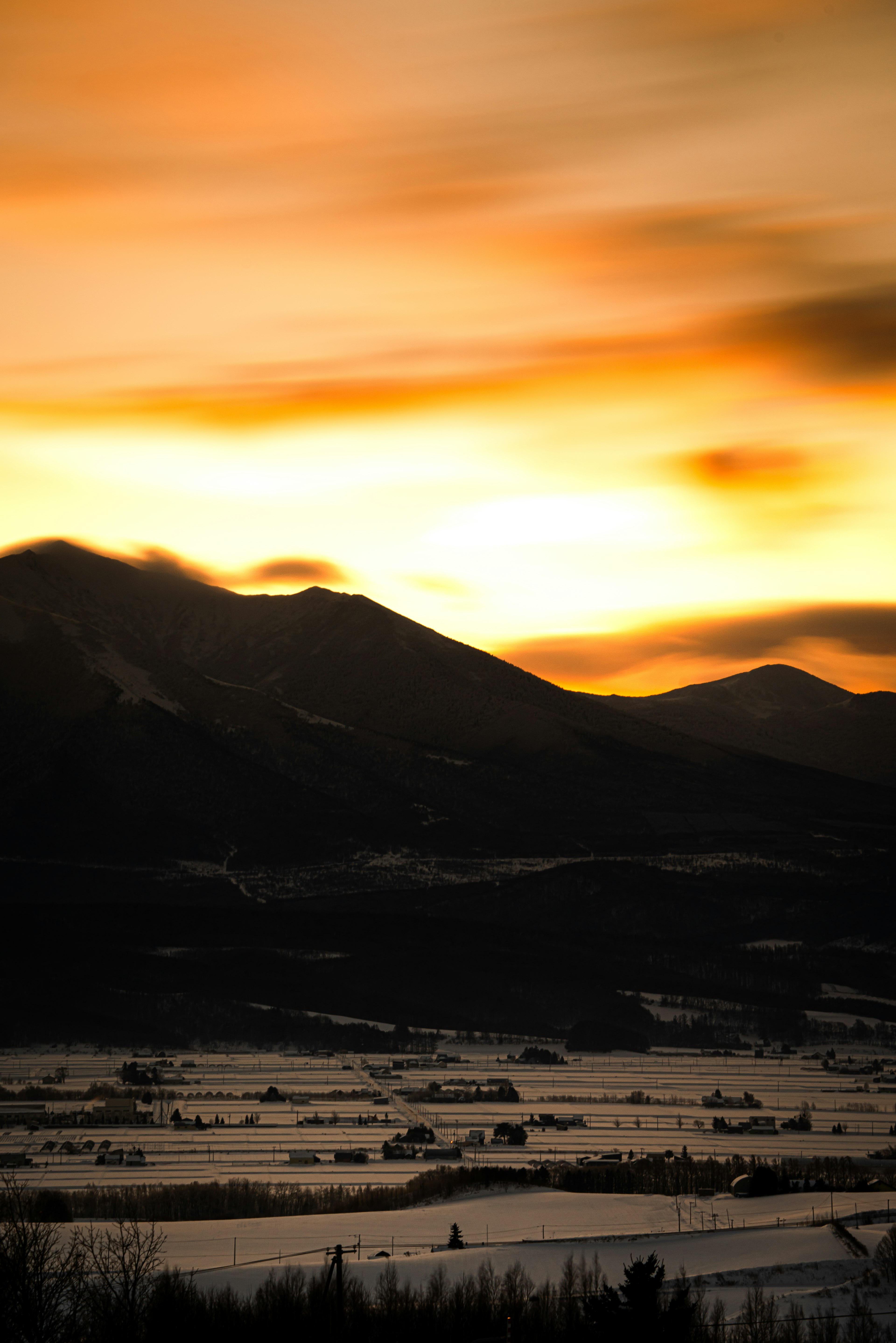 Impressionanter Sonnenuntergang über einer Berglandschaft mit lebhaftem orangefarbenem Himmel