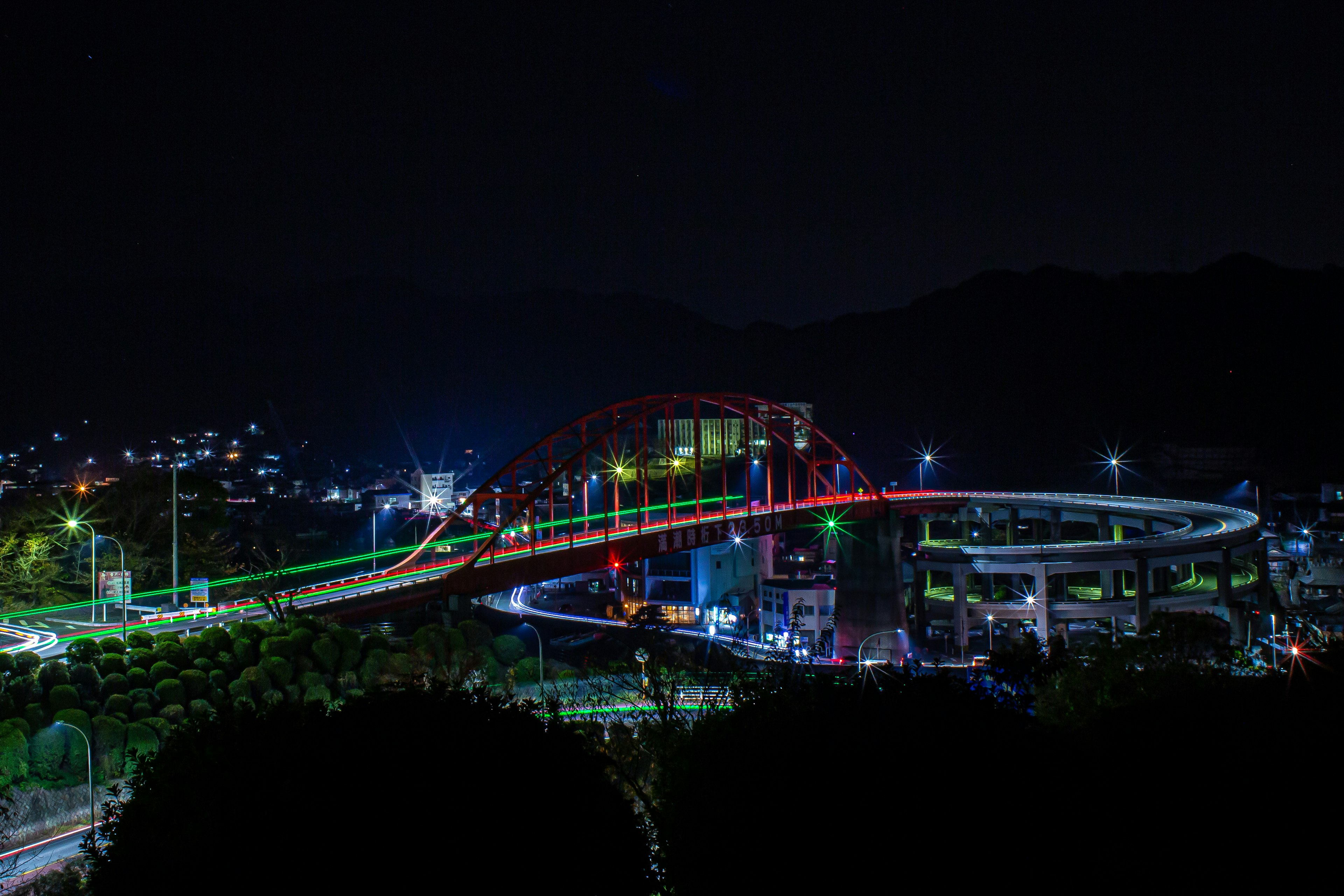 Vista nocturna de un puente colorido y paisaje urbano