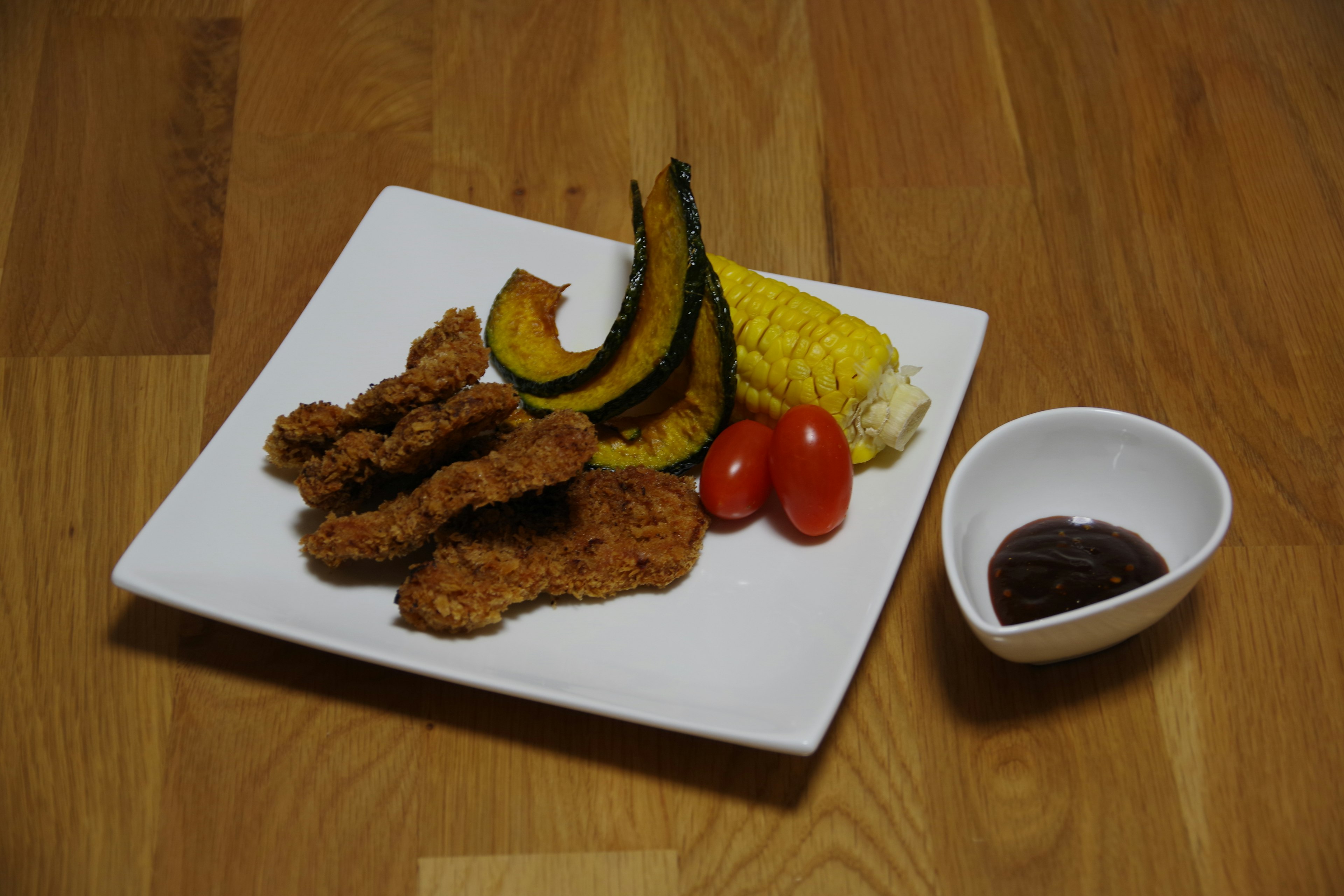 白い皿に盛り付けられたフライドチキンと野菜の盛り合わせ