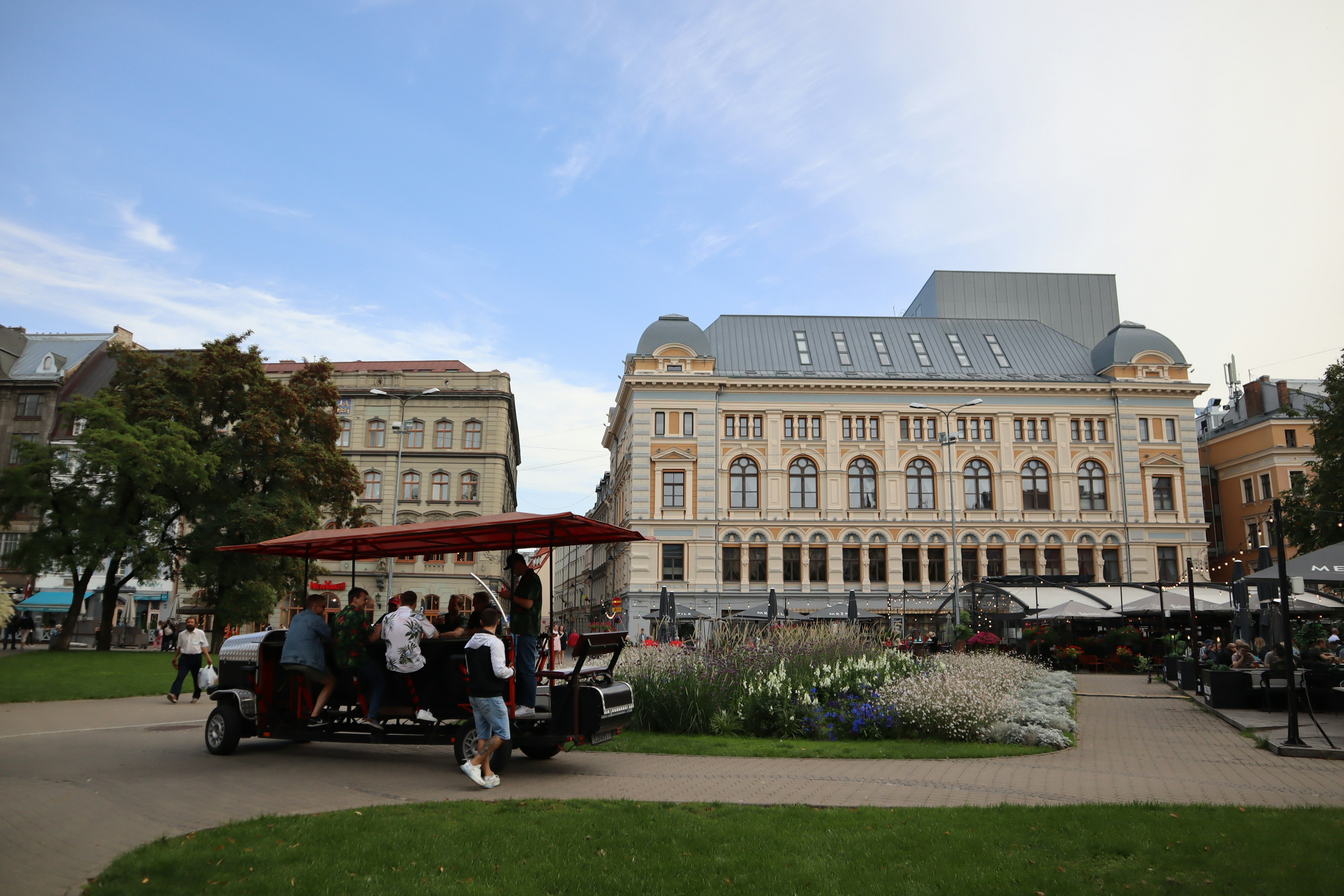 Véhicule touristique dans un parc avec un bâtiment historique en arrière-plan