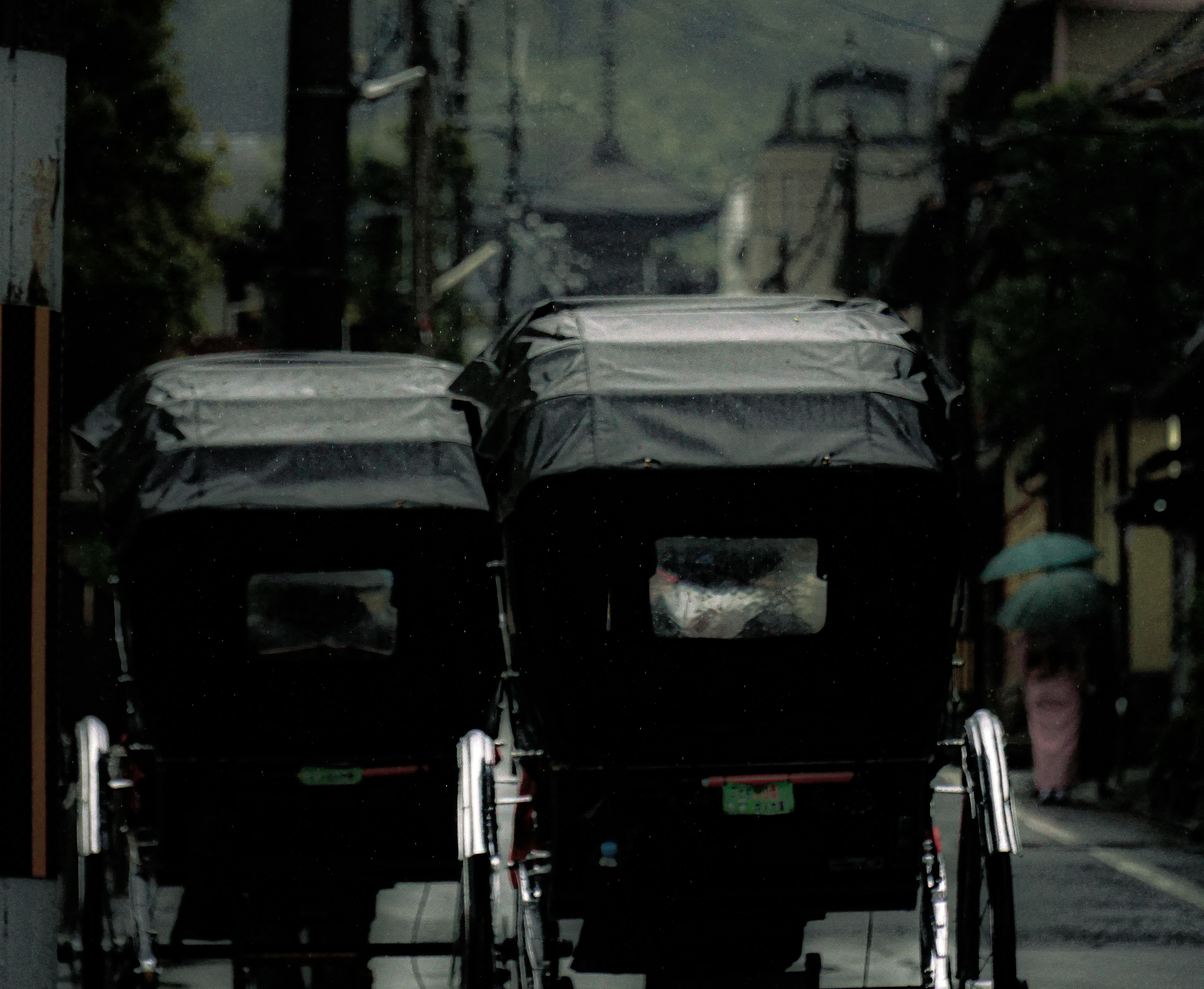 Dos rickshaws negros en una calle tranquila con fondo borroso