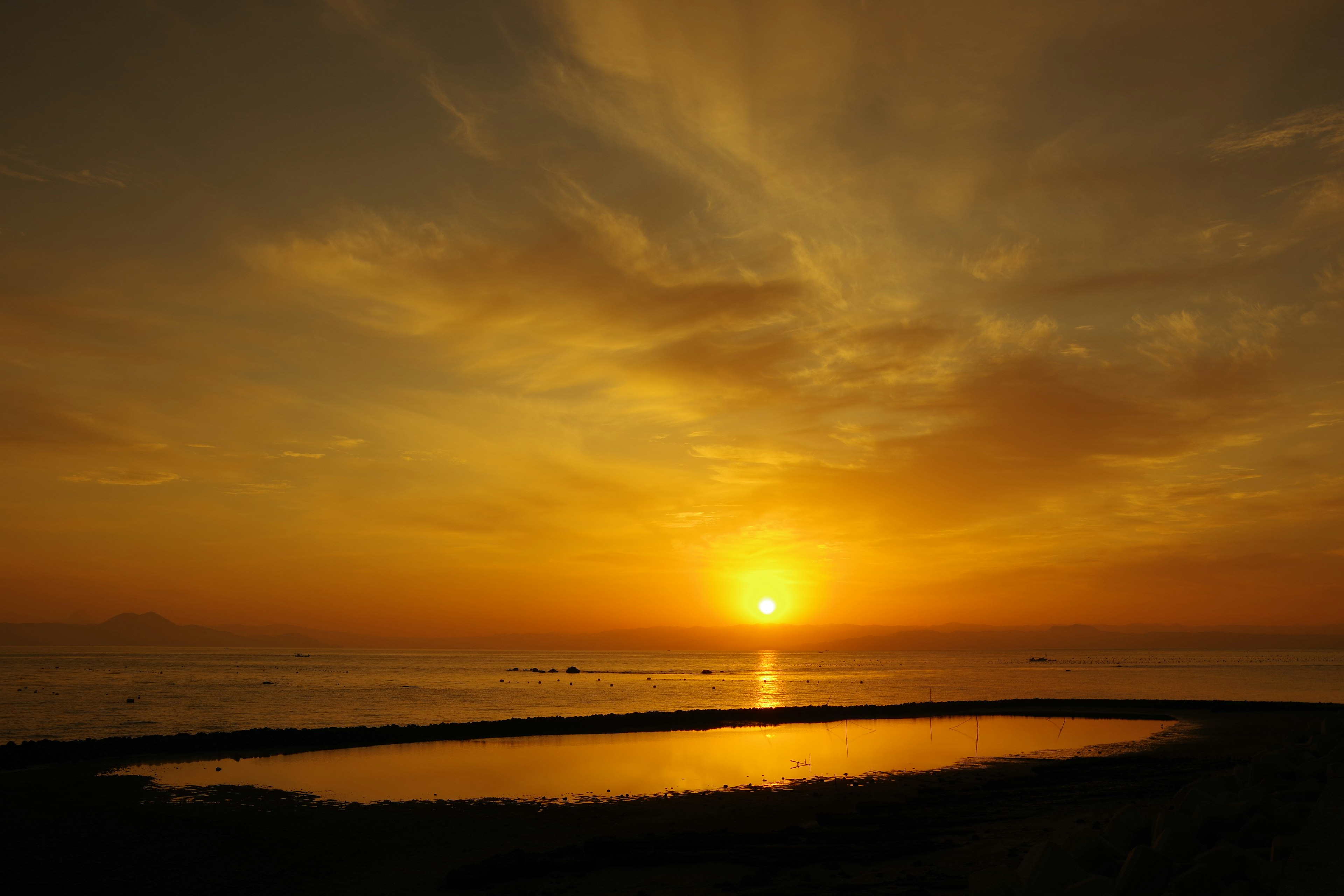 Schöne Landschaft eines Sonnenuntergangs über dem Ozean mit orangefarbenem Himmel