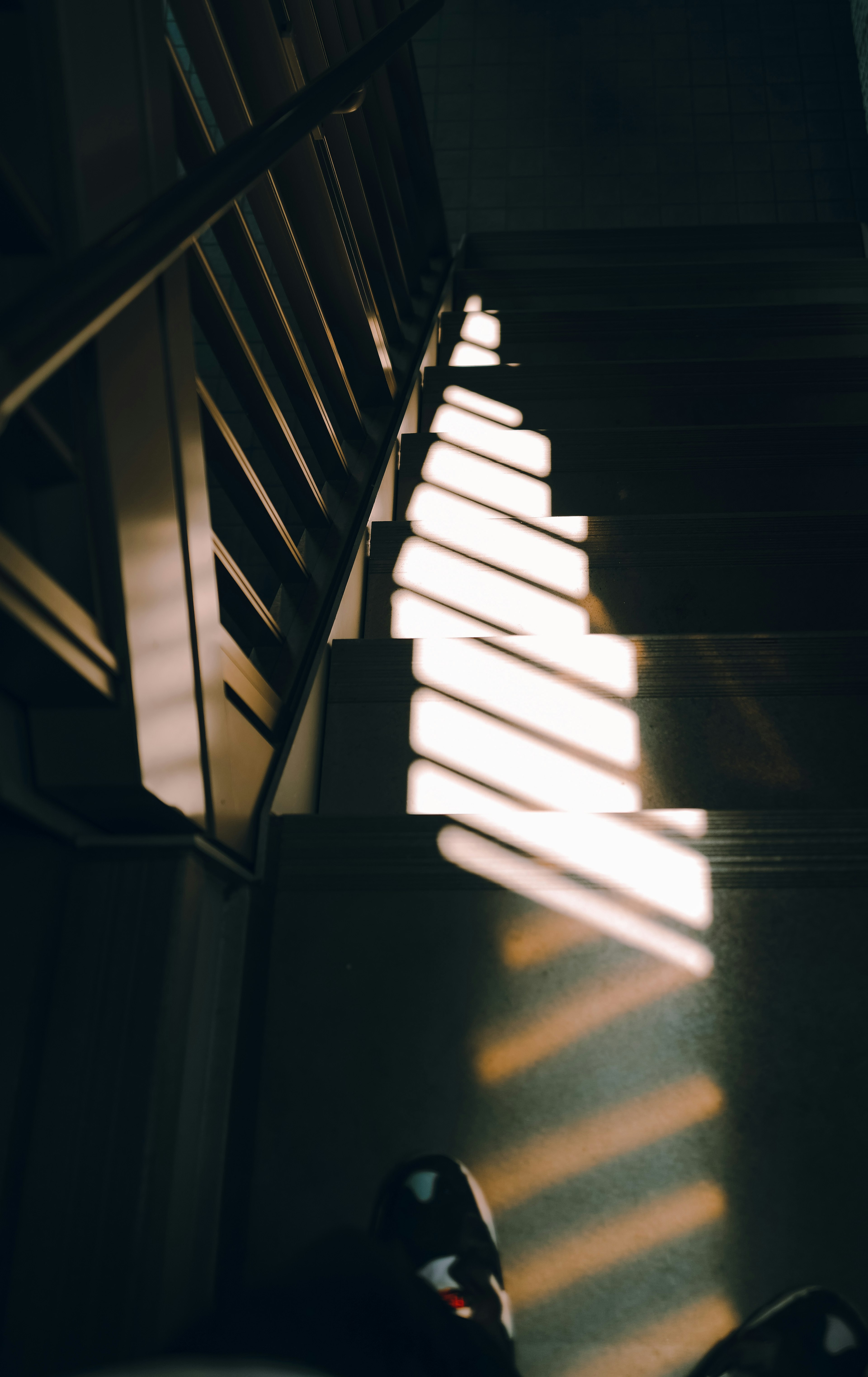 Sunlight casting shadows on stairs with a railing