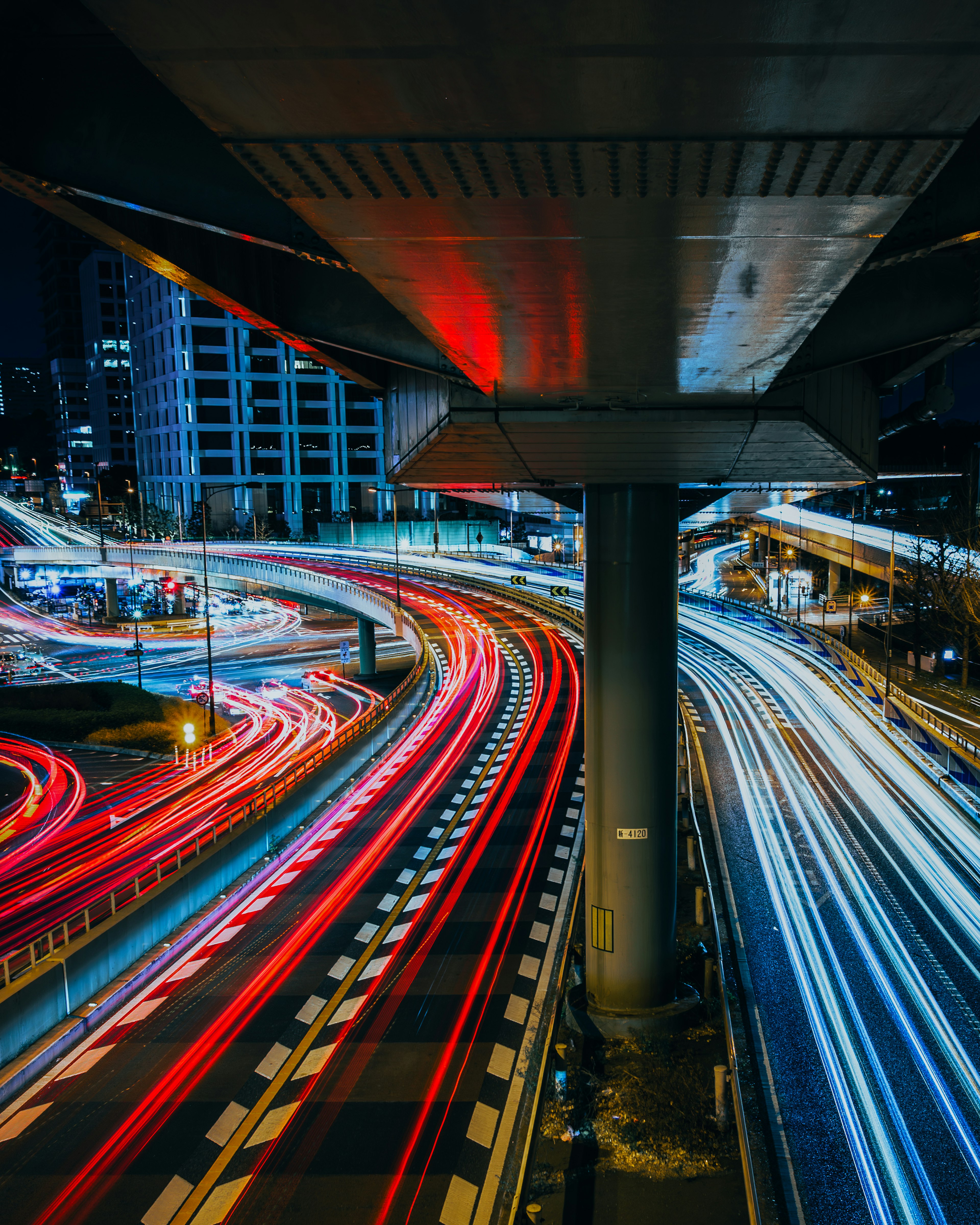 夜间高速公路上汽车的光轨迹与城市建筑背景