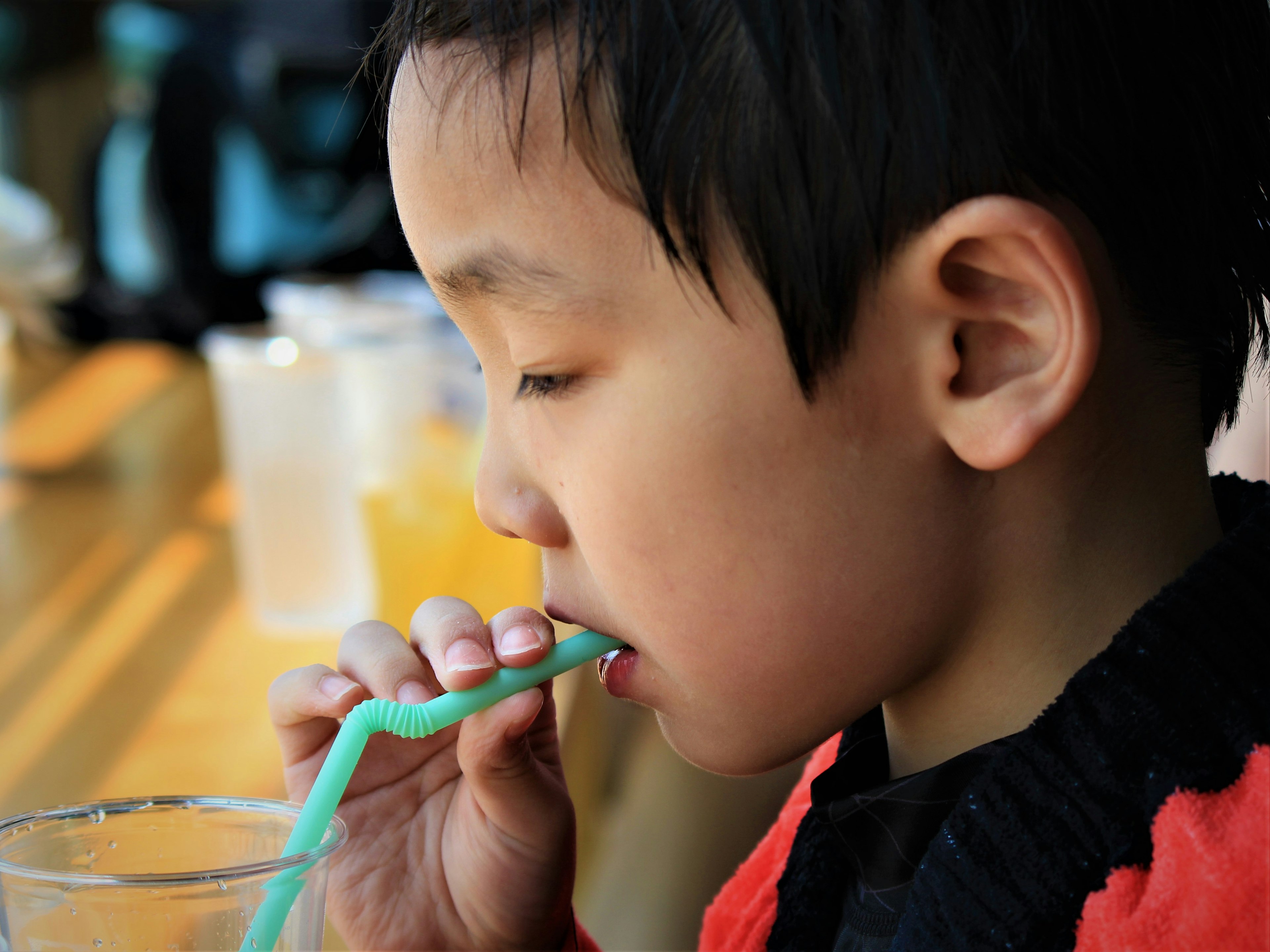 飲み物をストローで飲む少年の横顔