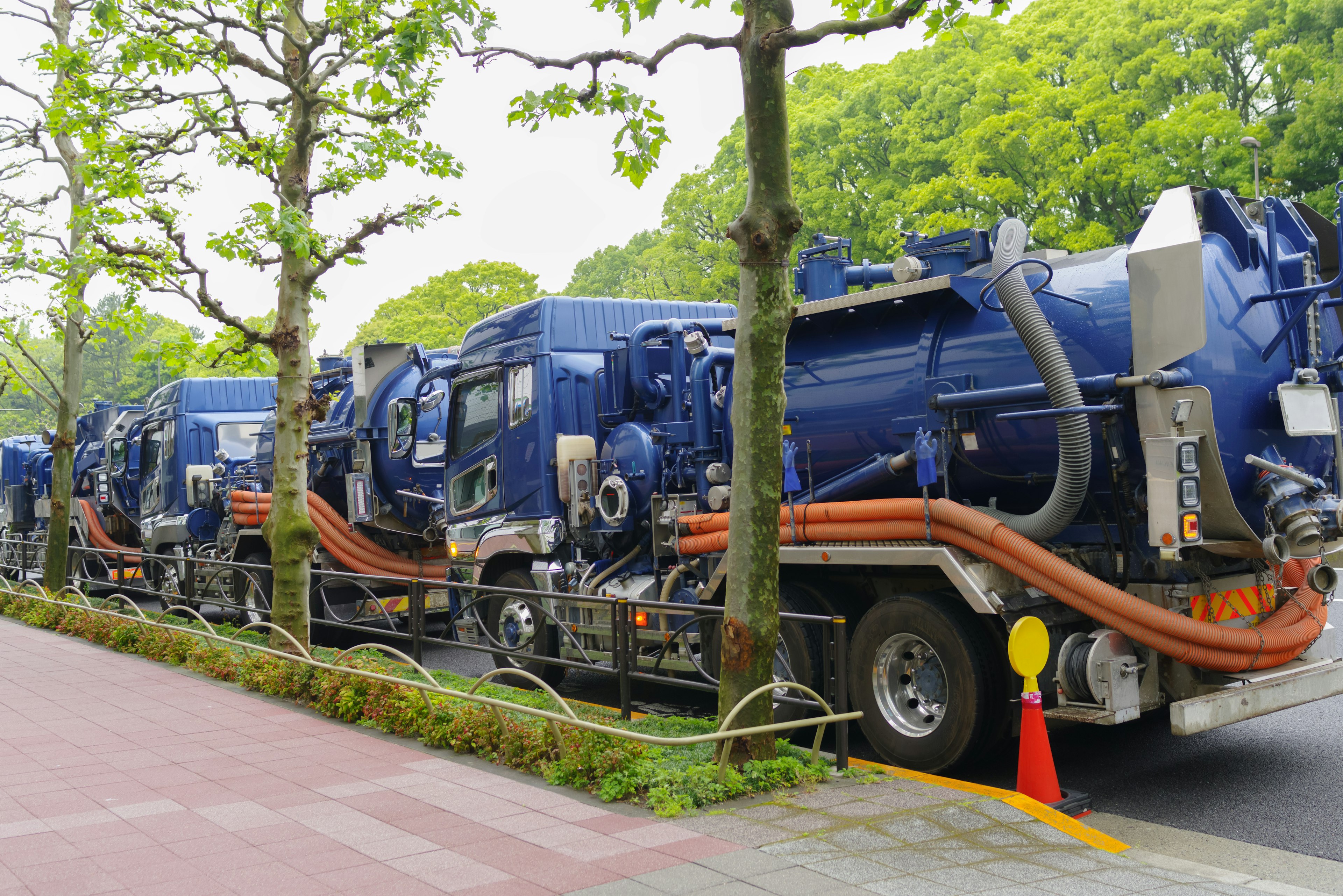 Barisan truk industri biru diparkir di sepanjang jalan