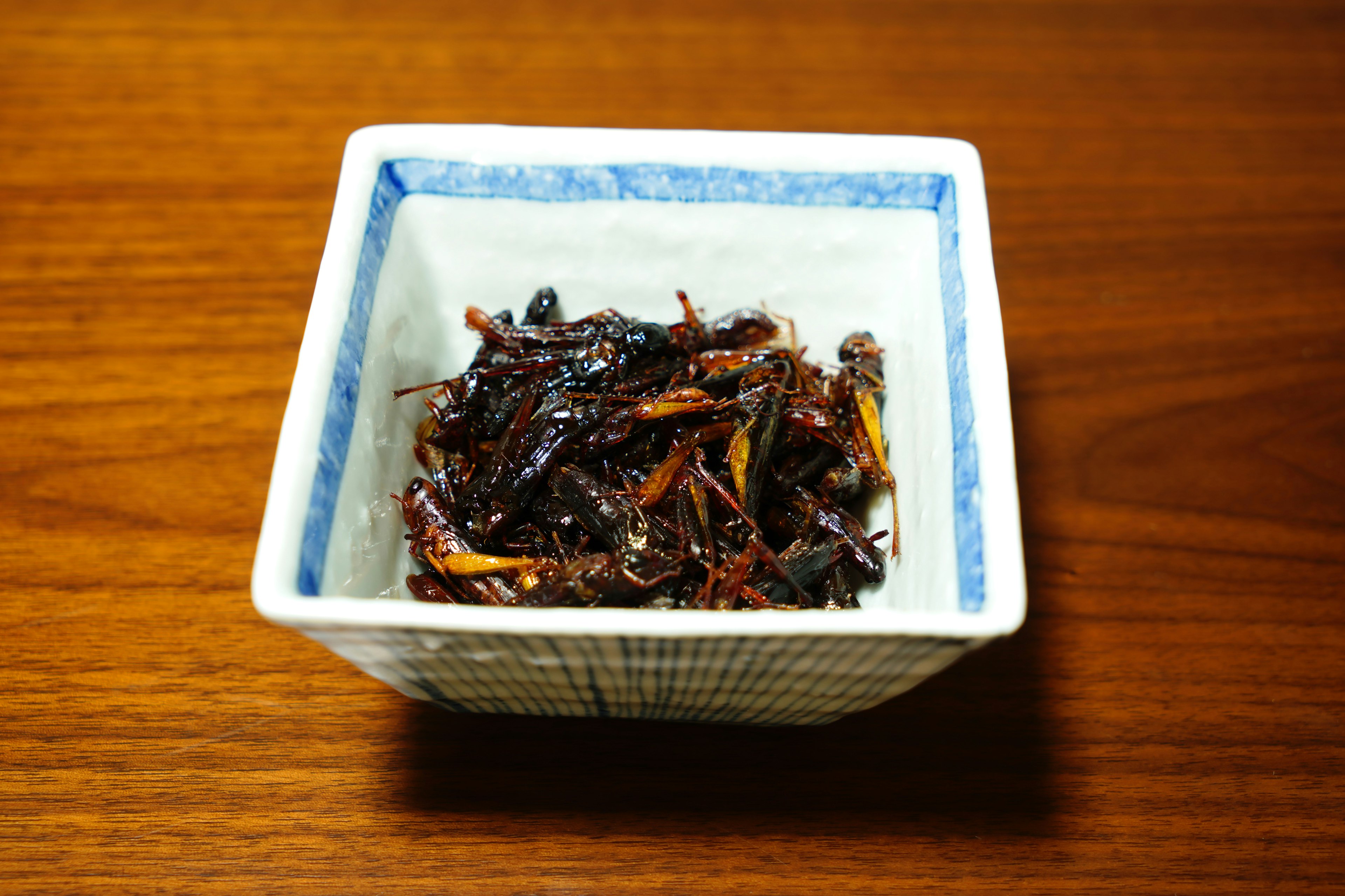 Small white bowl containing dark, caramelized kelp