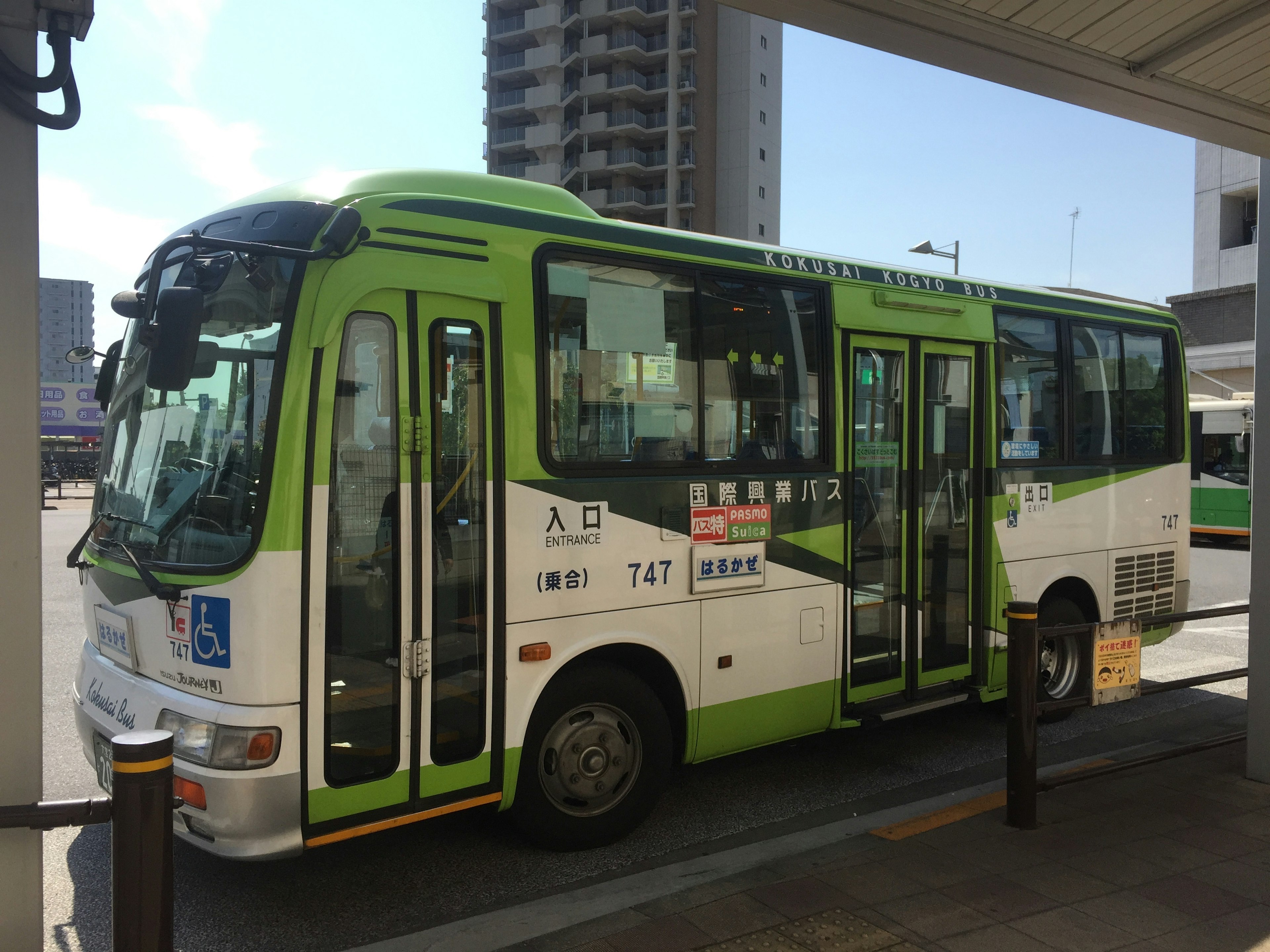 Green and white bus parked at a station