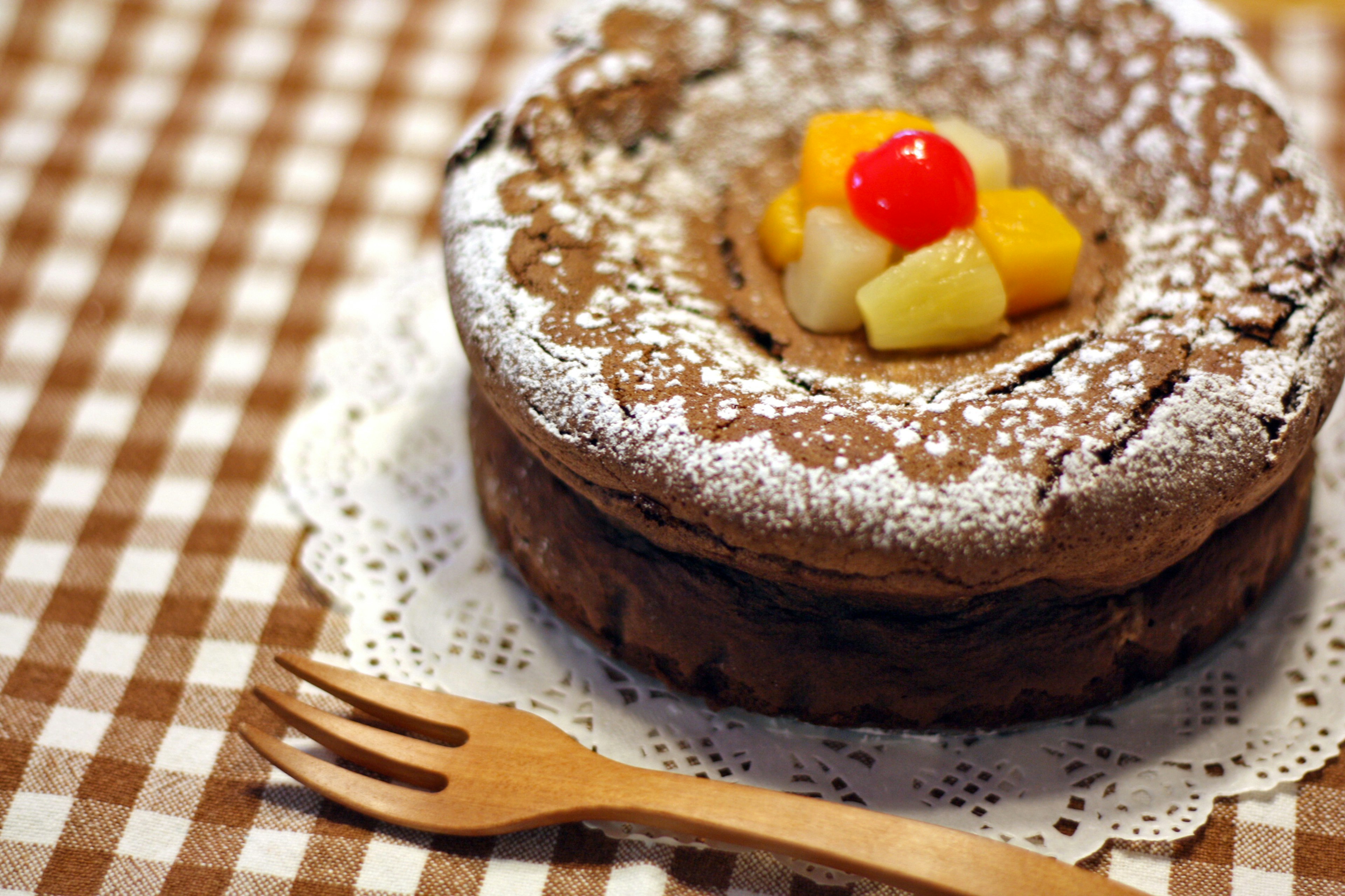 Schokoladenkuchen mit Früchten und Puderzucker garniert