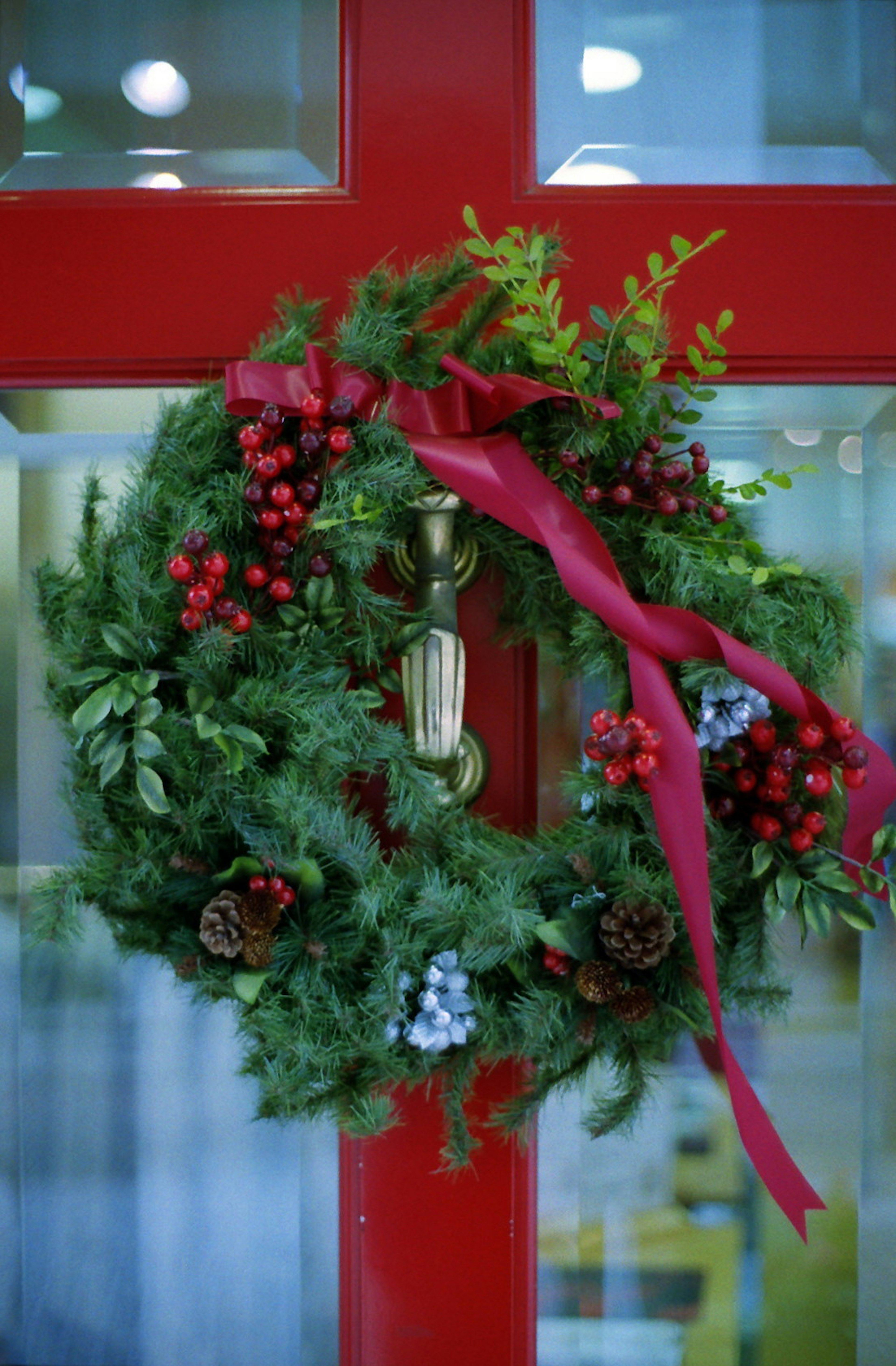 Couronne verte avec un ruban rouge sur une porte rouge