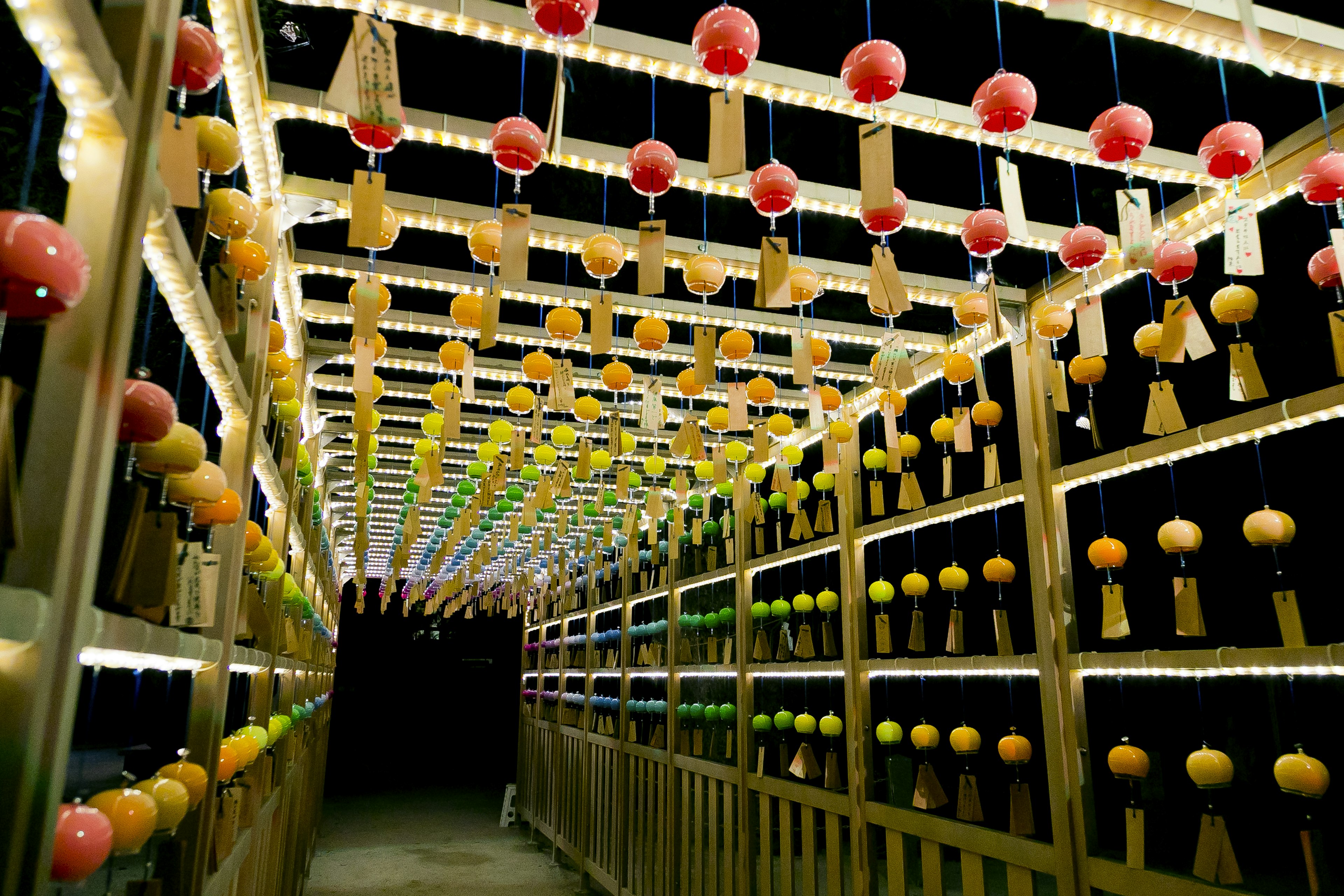 Tunnel di lanterne colorate e luci in un passaggio notturno