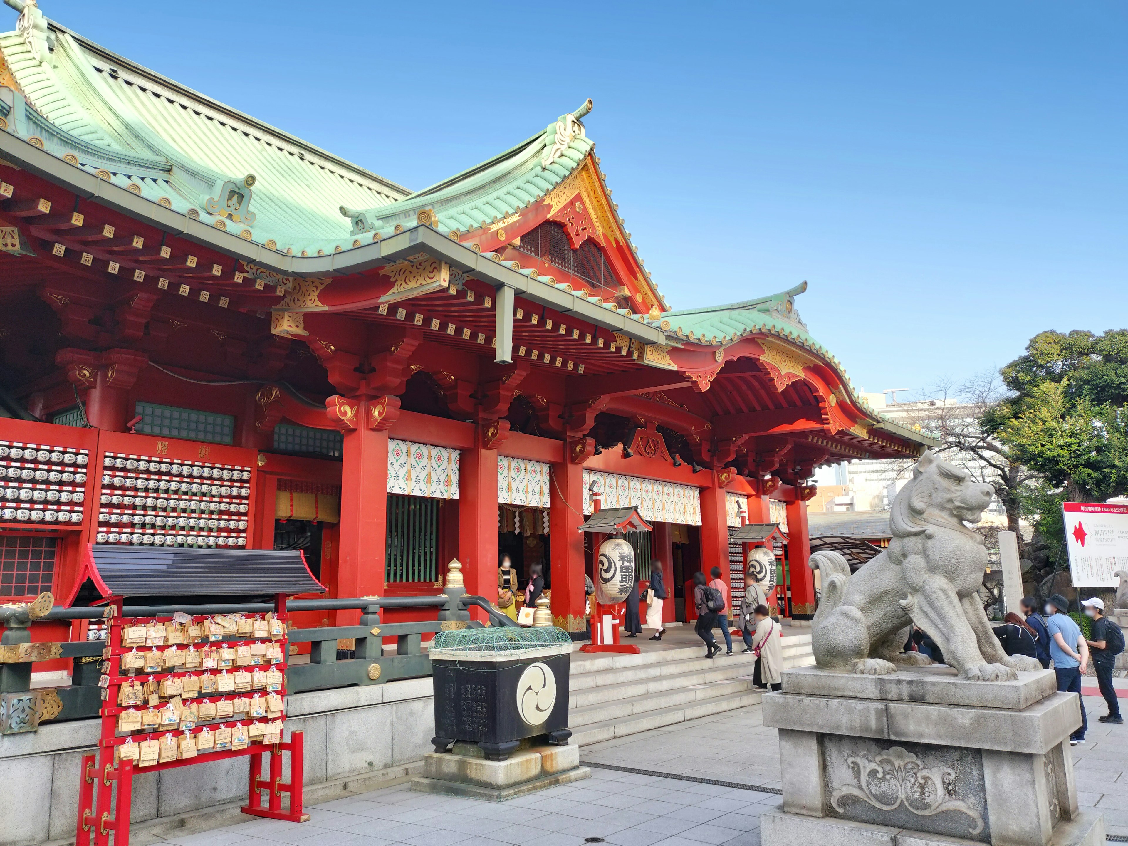 一座色彩鮮豔的神道神社，紅色屋頂和獅子狗雕像